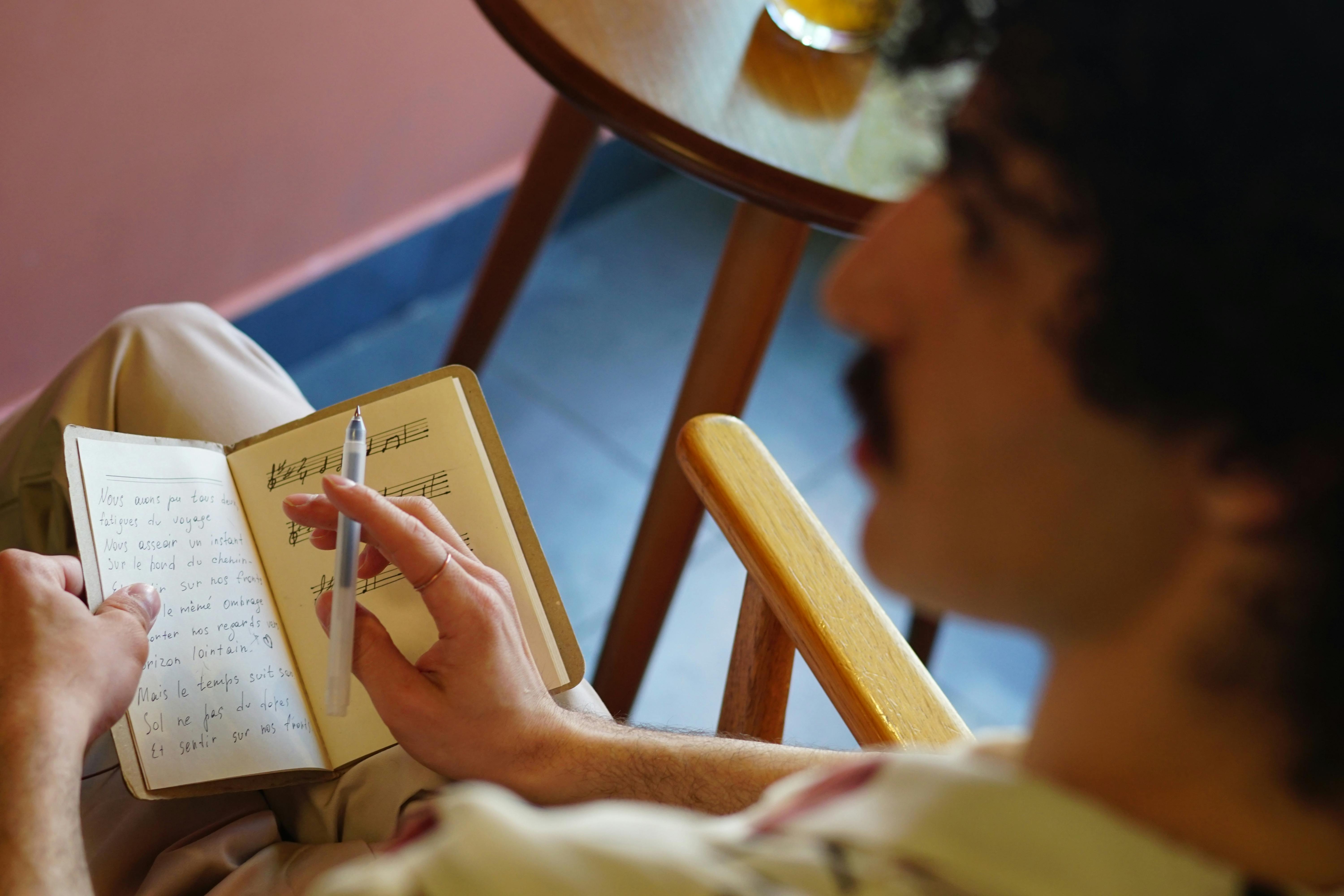 A Man with a Mustache Holding a Pen and a Notebook