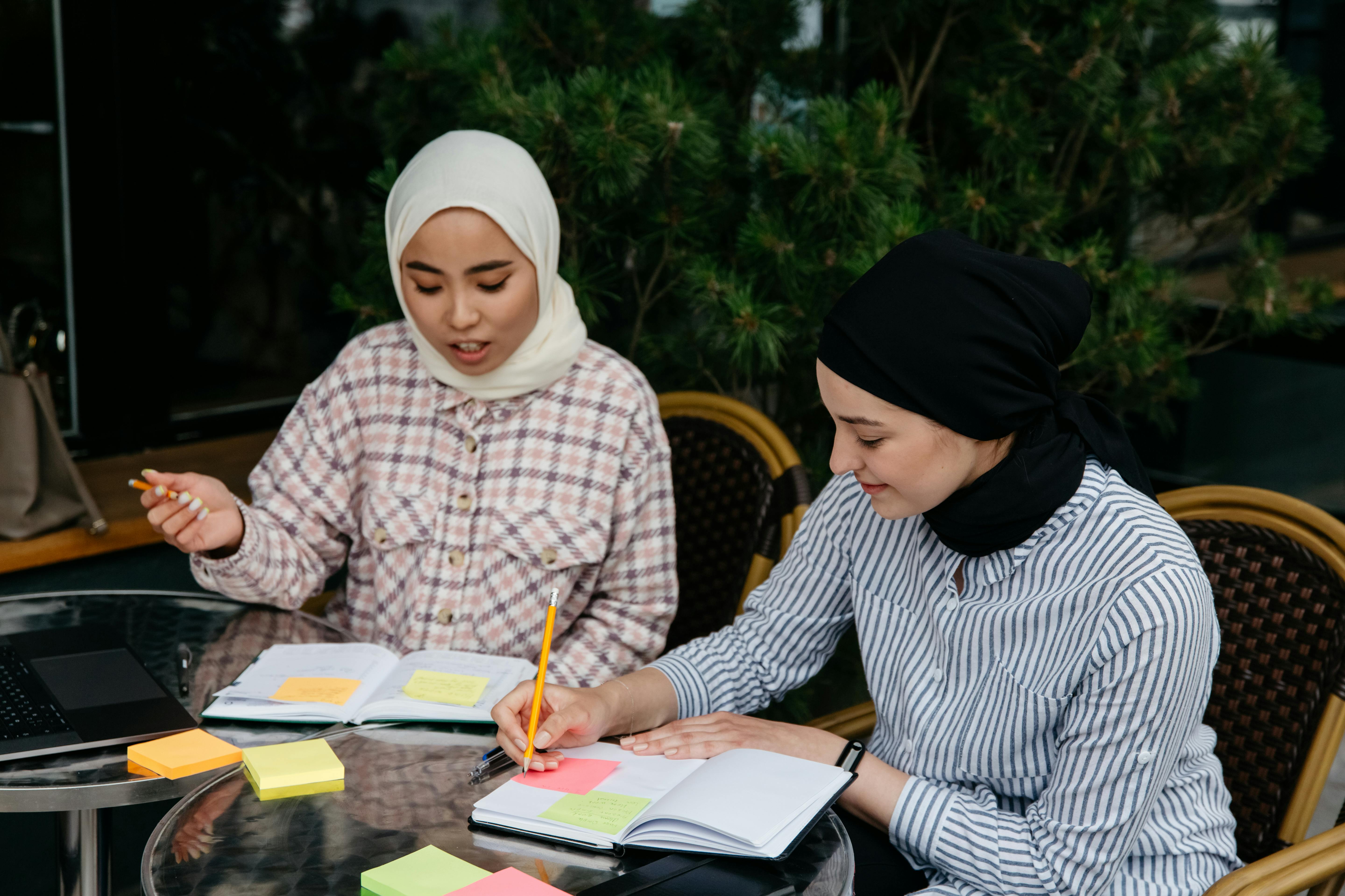 Friends Sitting at a Table Making Notes in Schedules