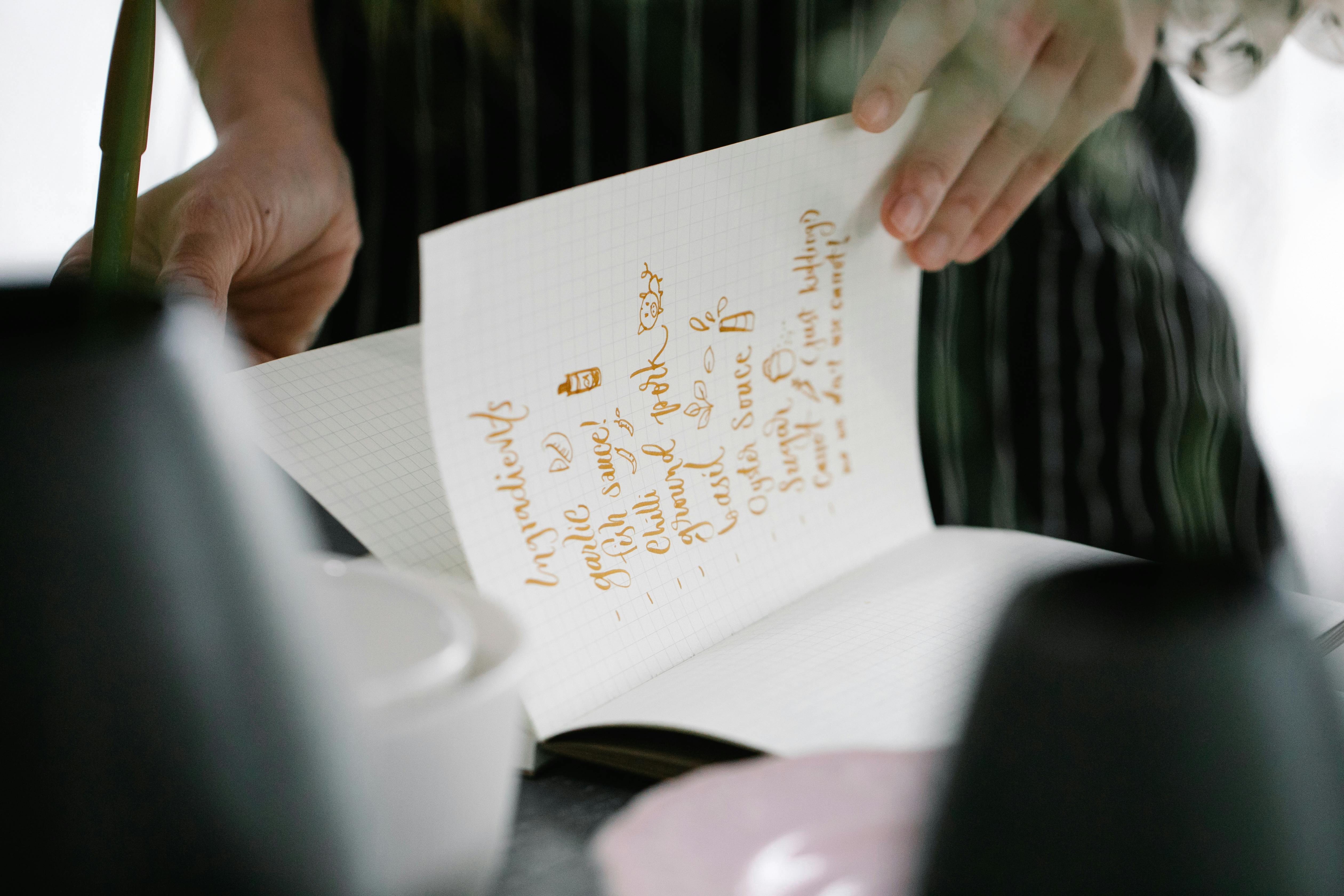 Woman Holding Notebook with Handwritten Ingredients
