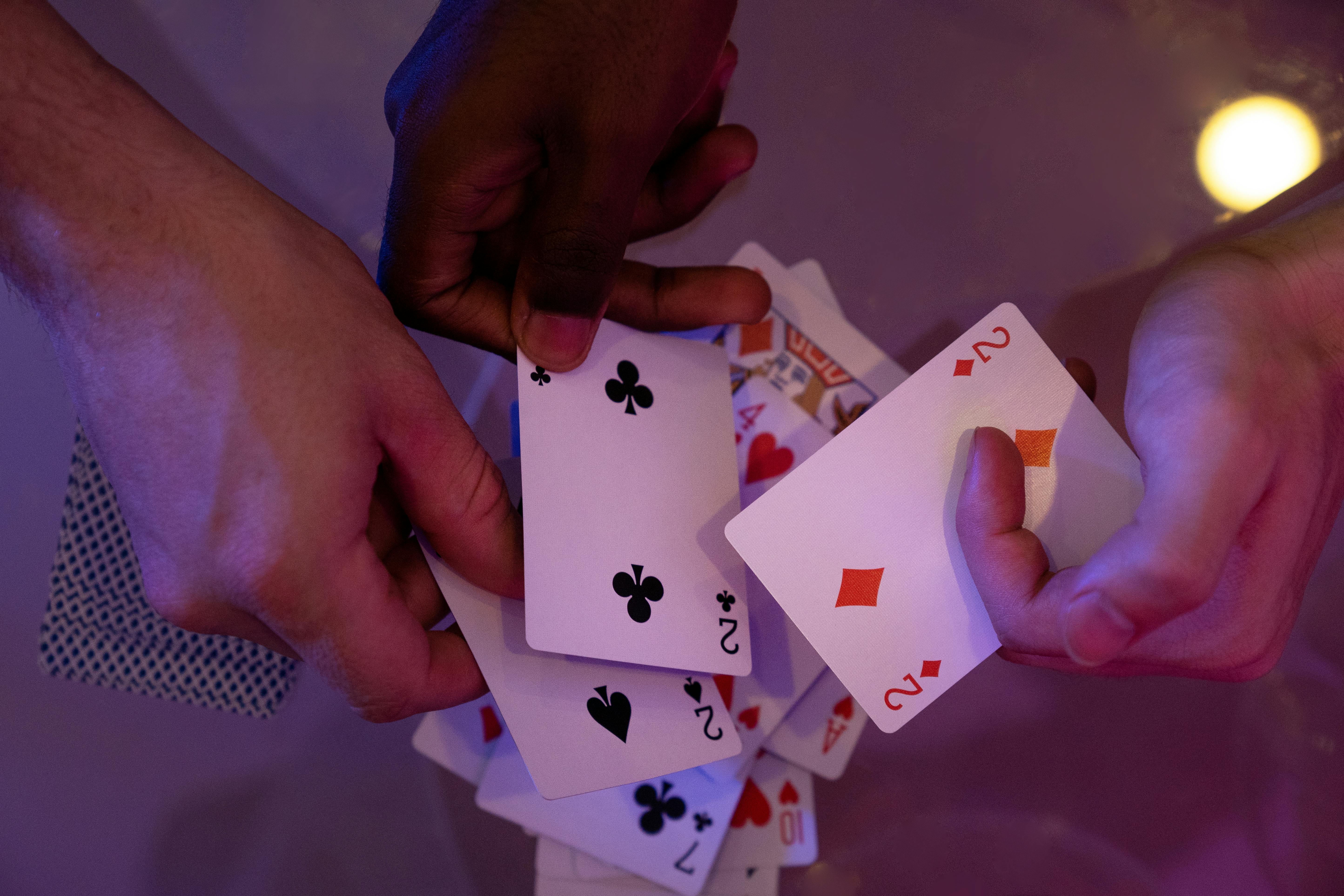 People Holding a Playing Cards