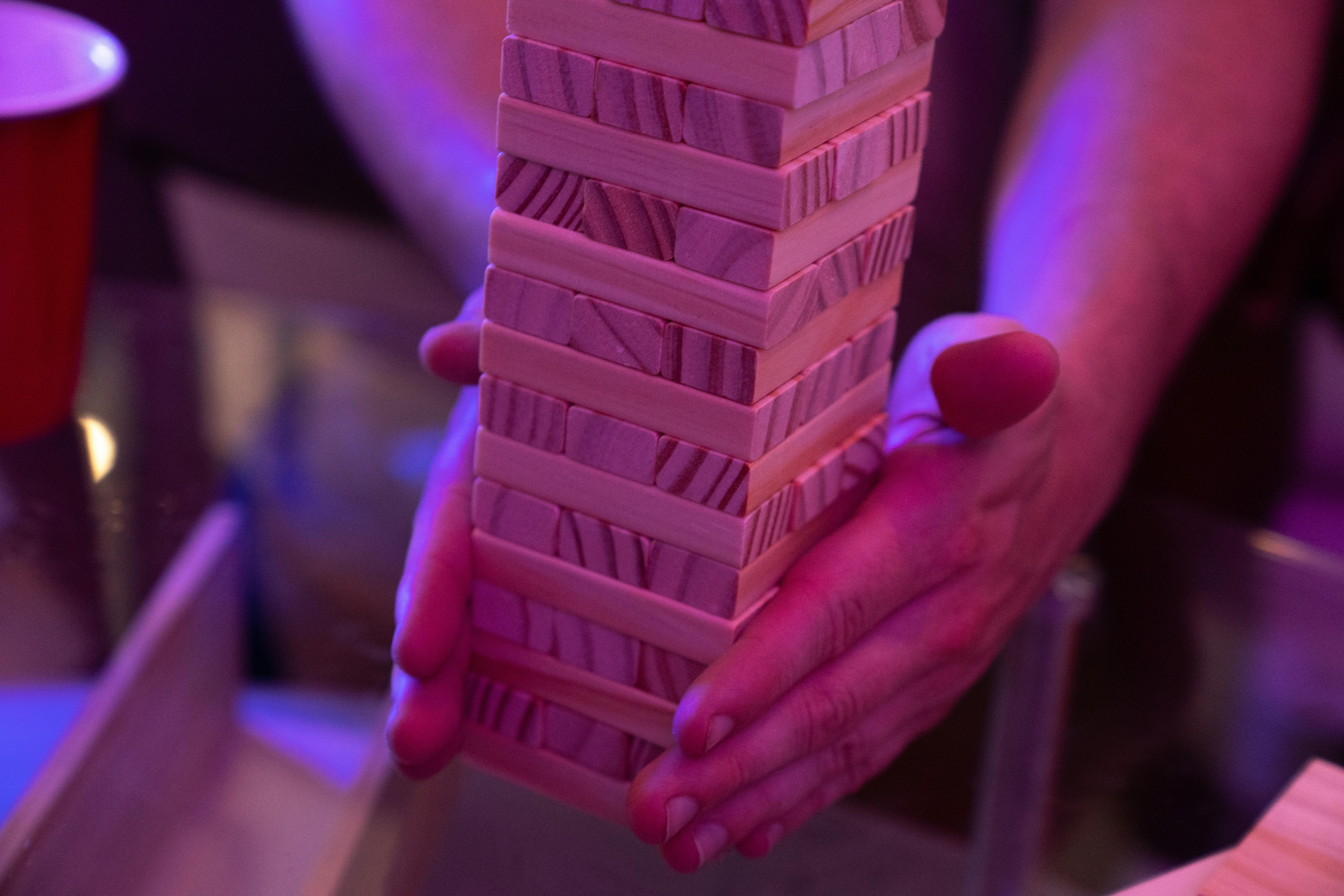Close-Up Shot of a Person Holding Jenga Blocks