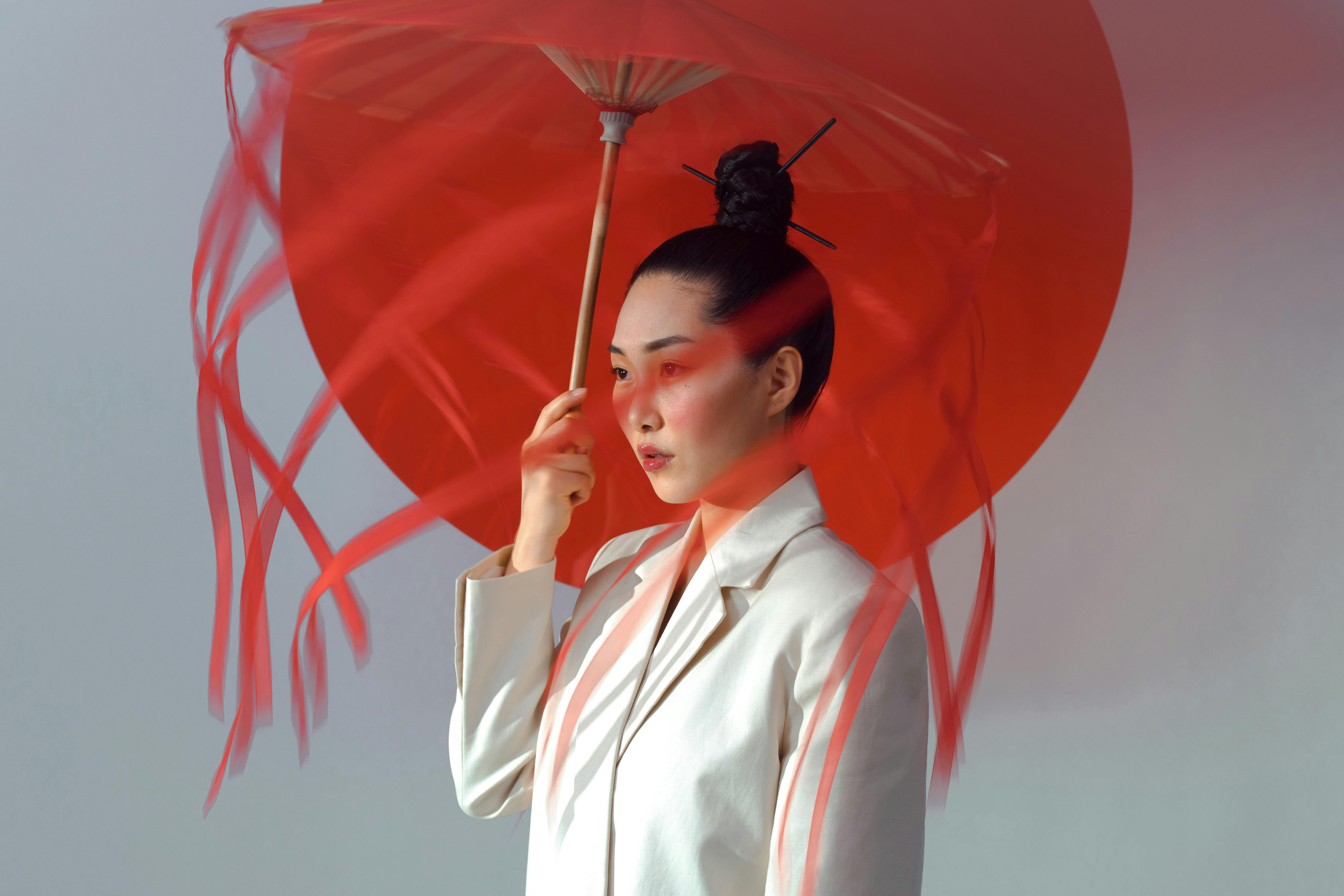 A Woman in White Blazer Holding an Umbrella