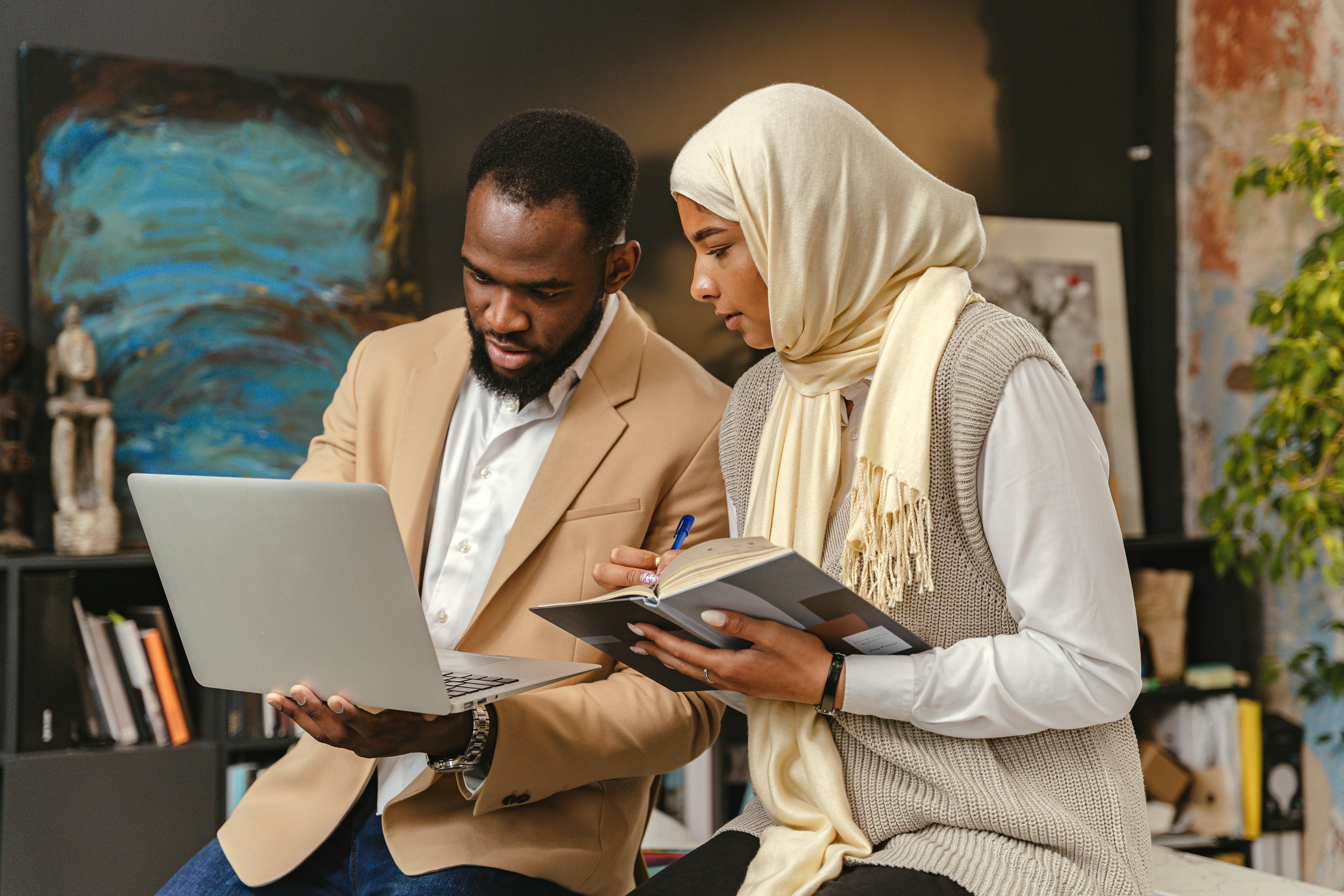 Man and a Woman Looking at a Laptop