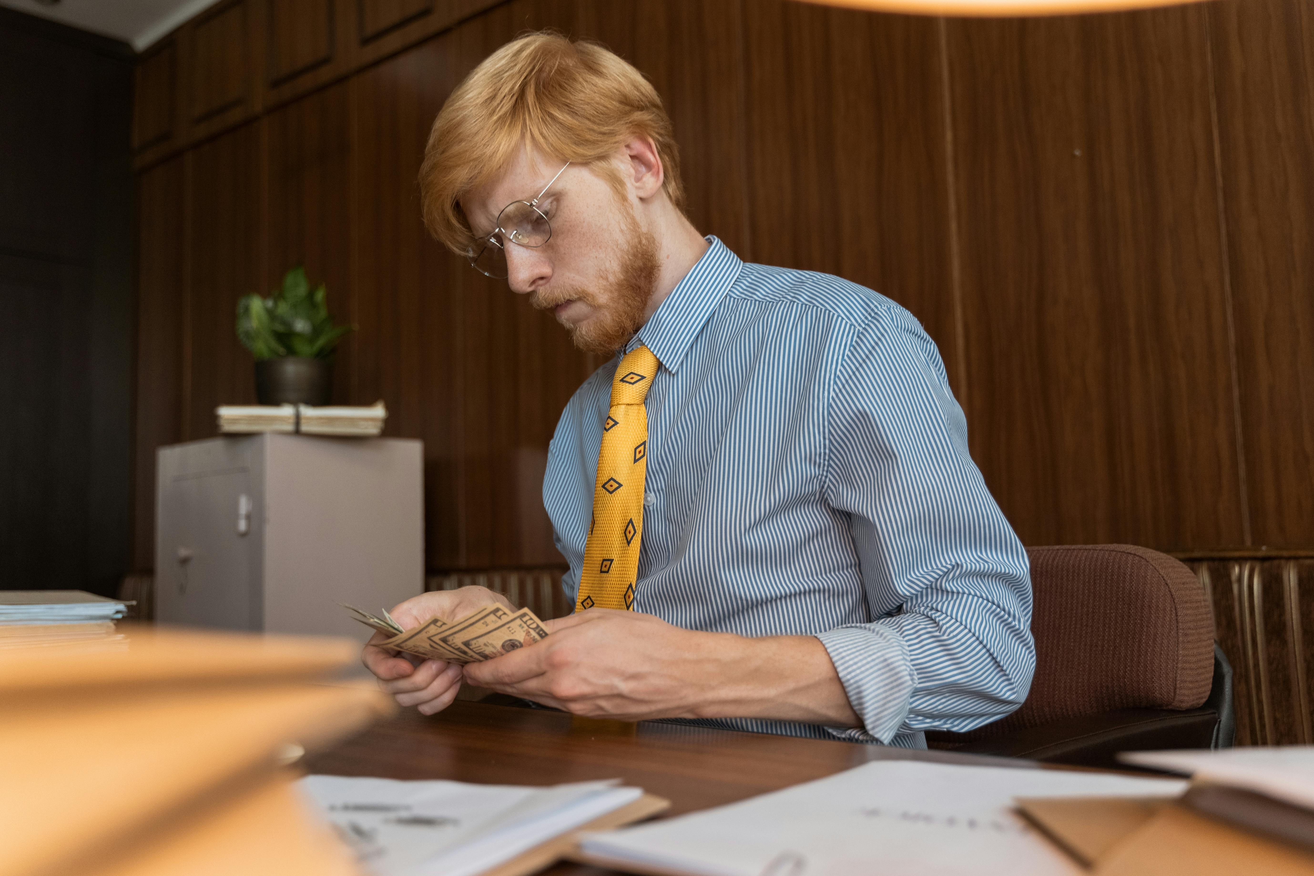 A Man Counting Money in the Office