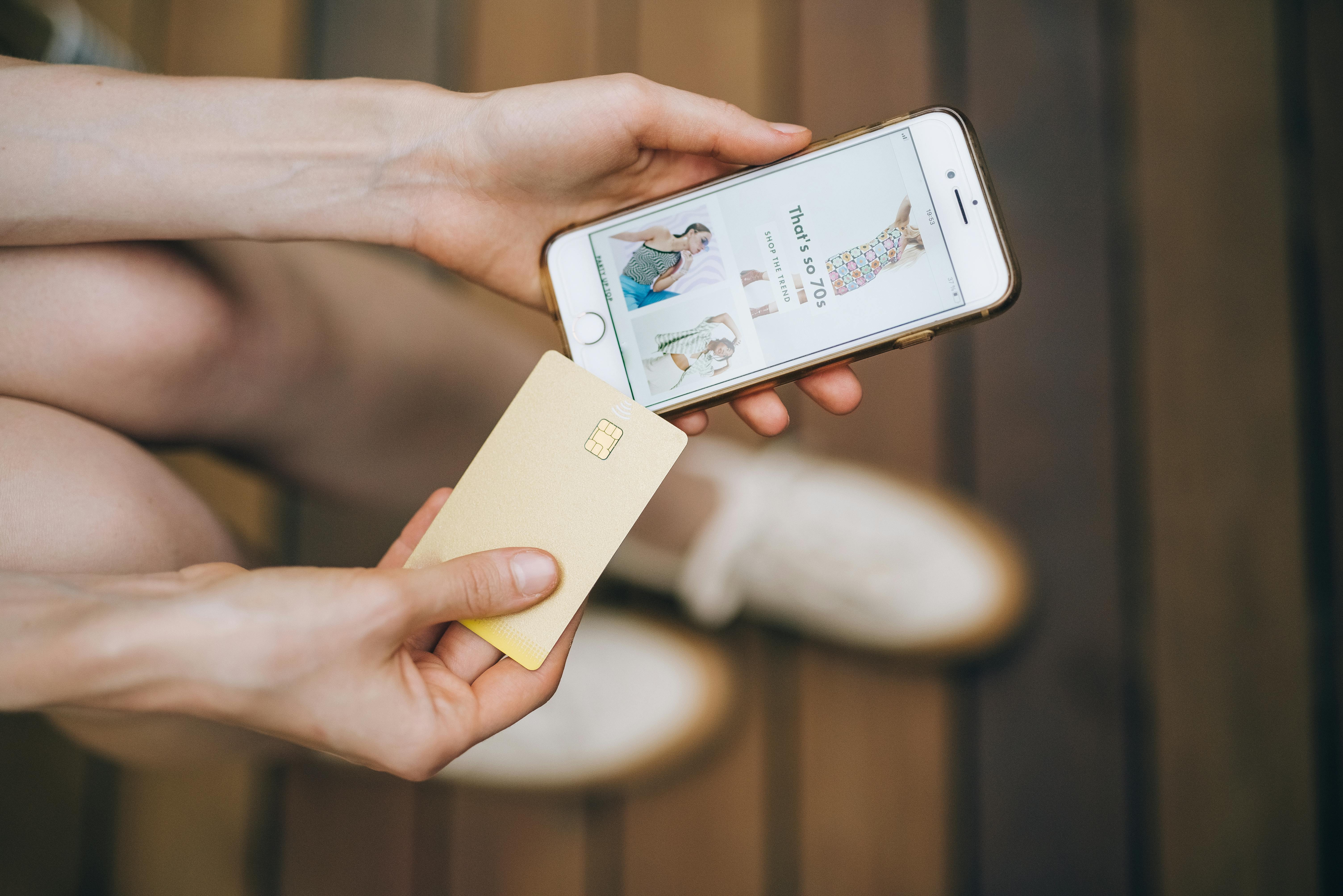 Person Holding an iPhone and a Card