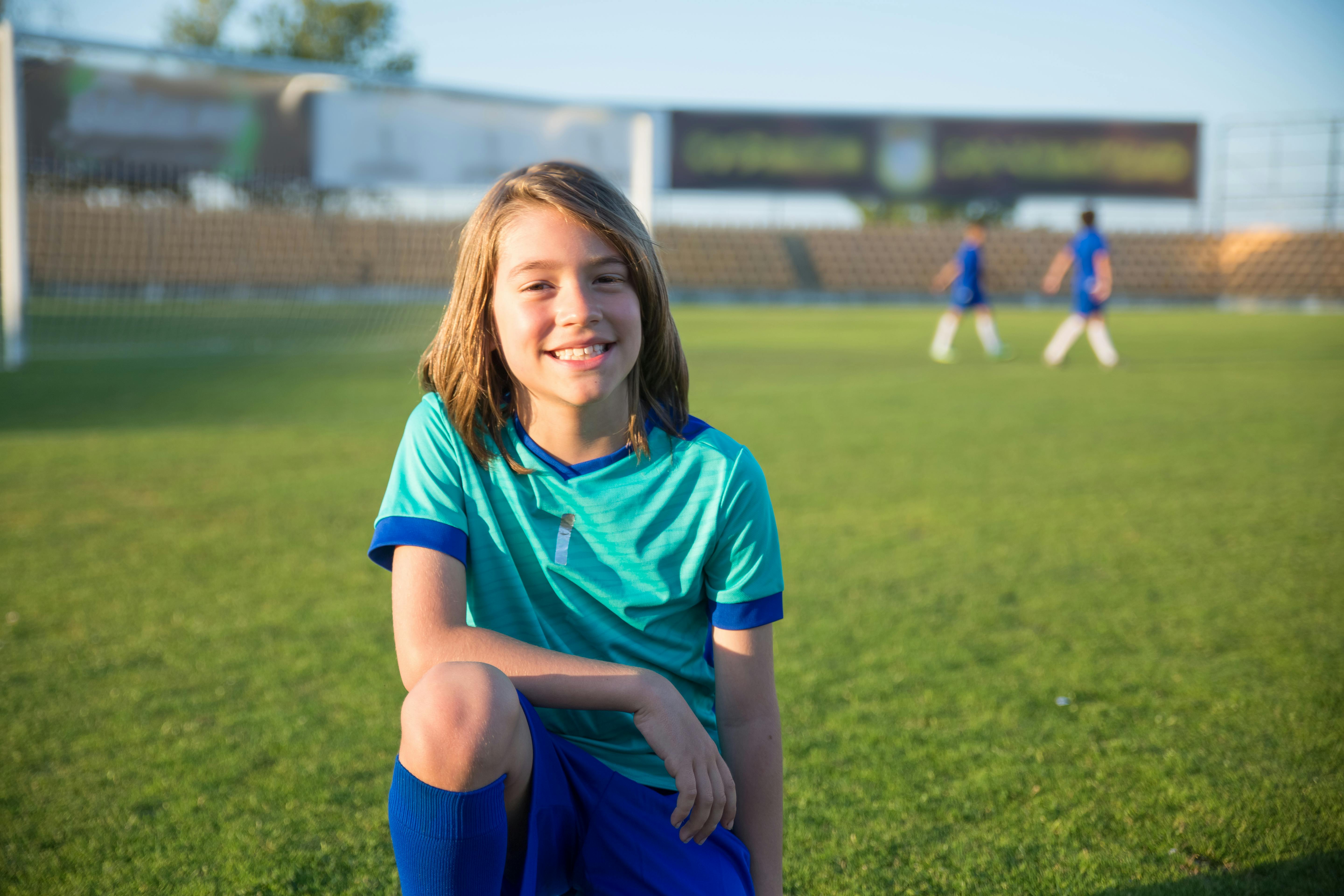 Boy with Long Hair Wearing Blue Jersey