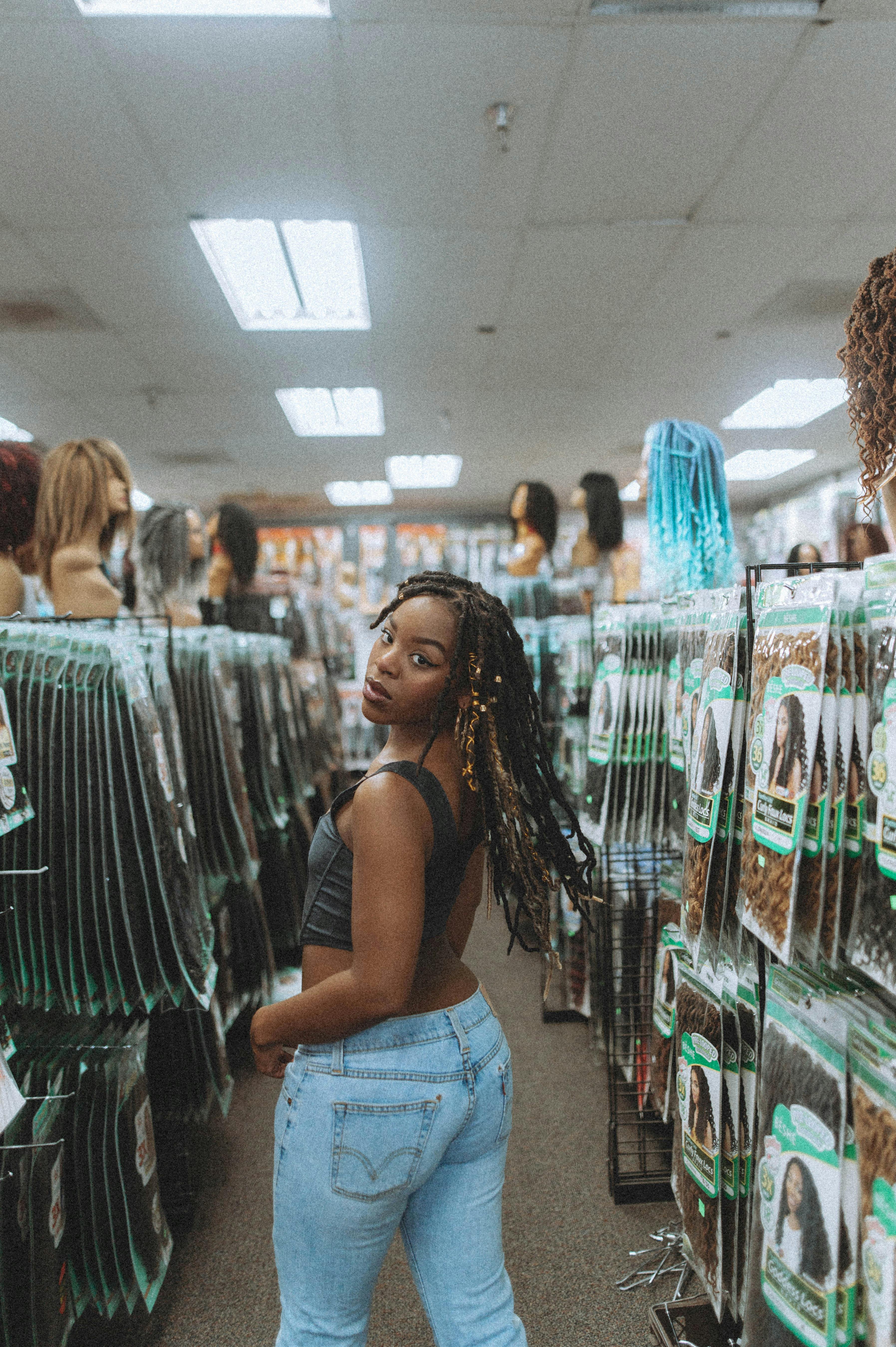 A Woman in Black Tank Top and Denim Jeans Standing Inside the Shop