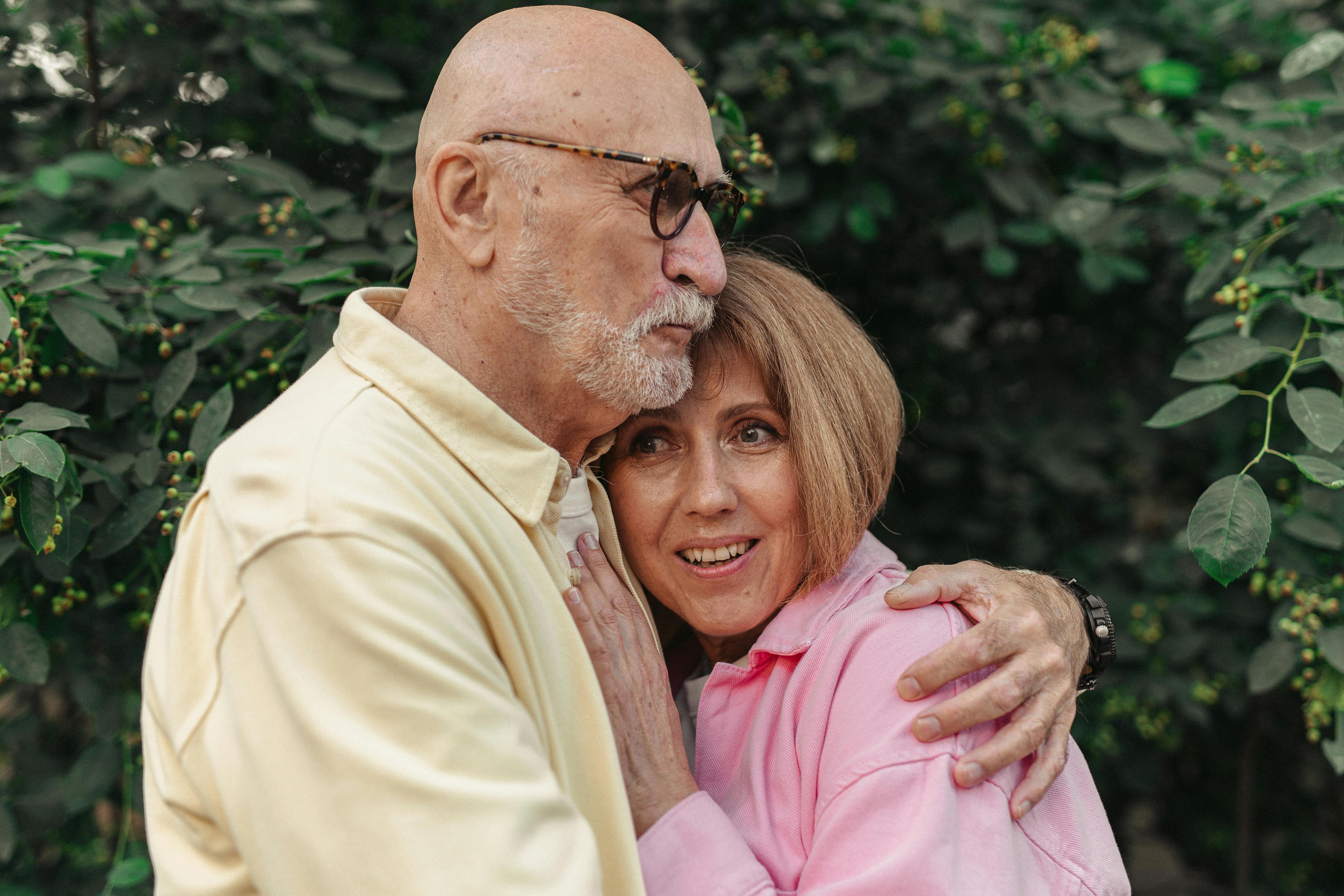 Man in Beige Dress Shirt Embracing A Woman in Pink Dress Shirt
