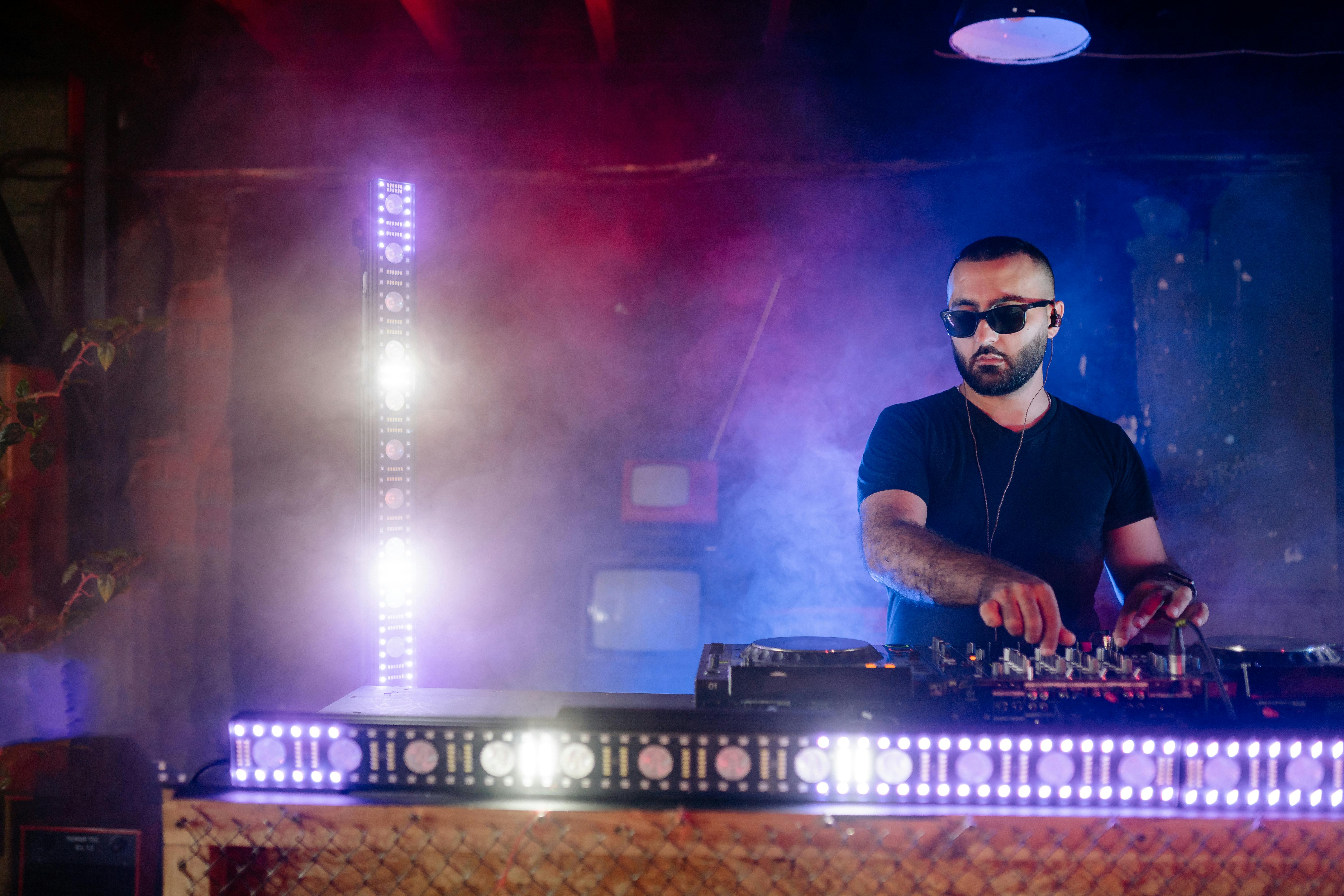 A Man with Black Sunglasses Playing the Dj Mixer