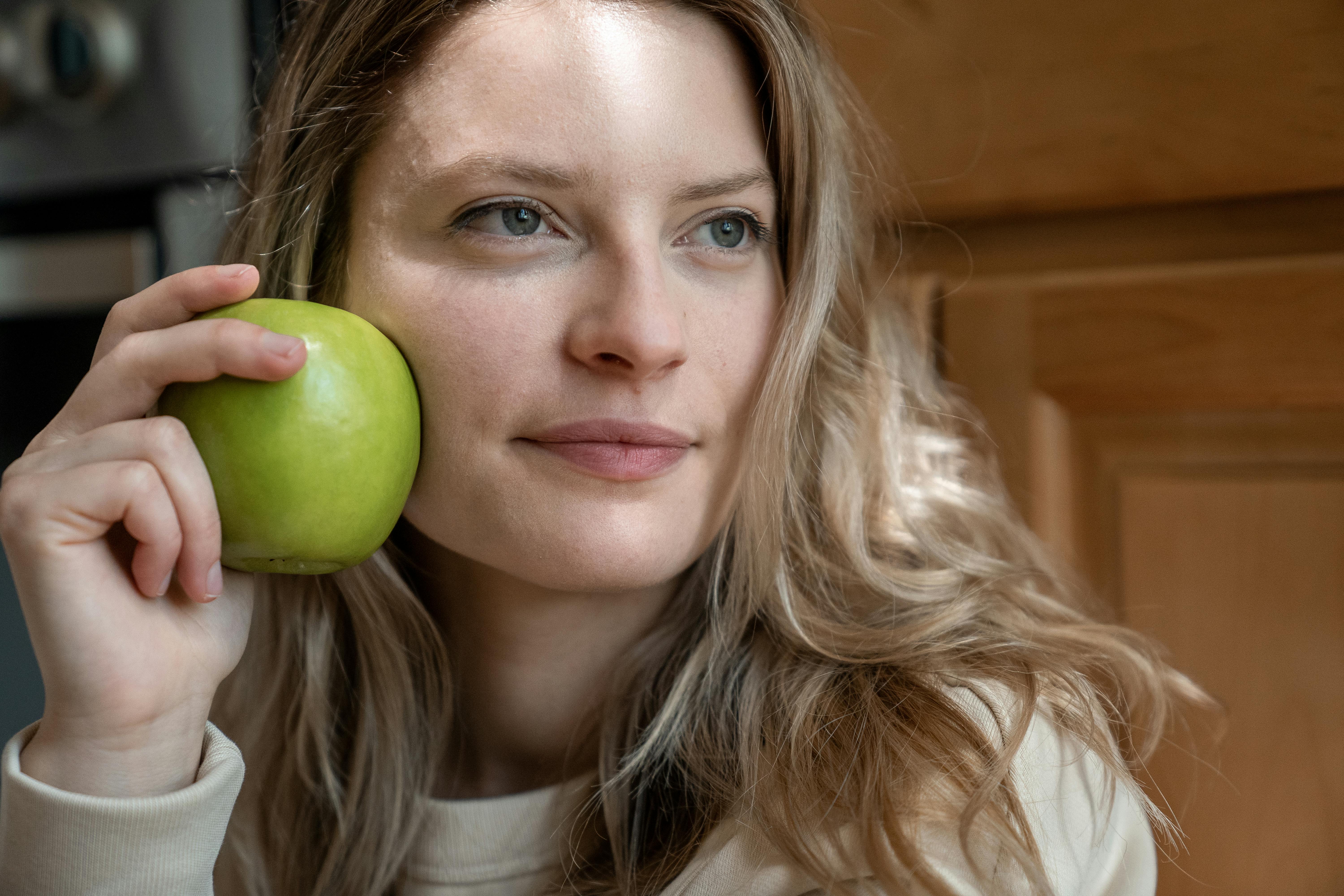 A Woman Holding a Green Apple