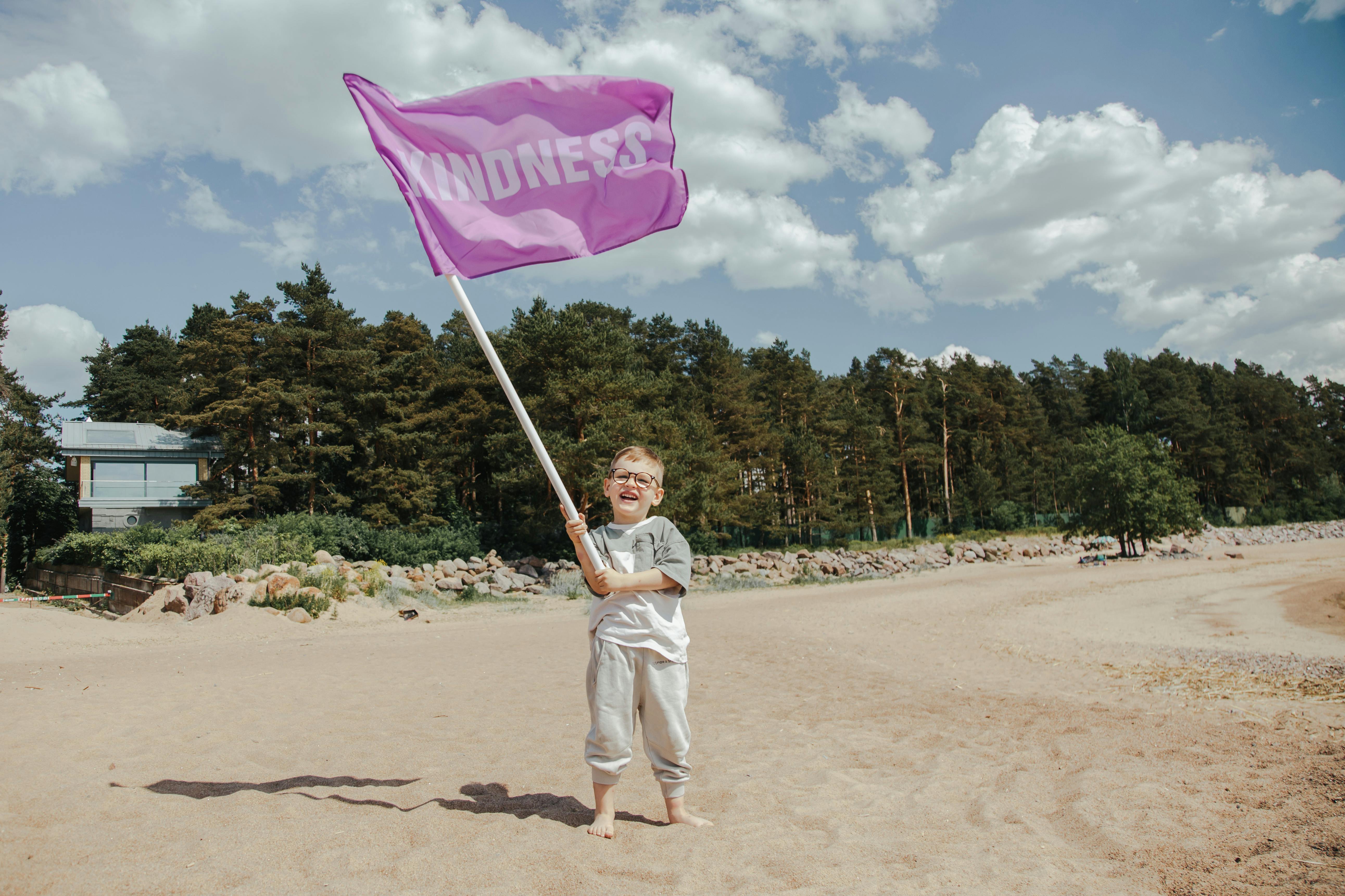 A Young Boy Waving a Pink Flag