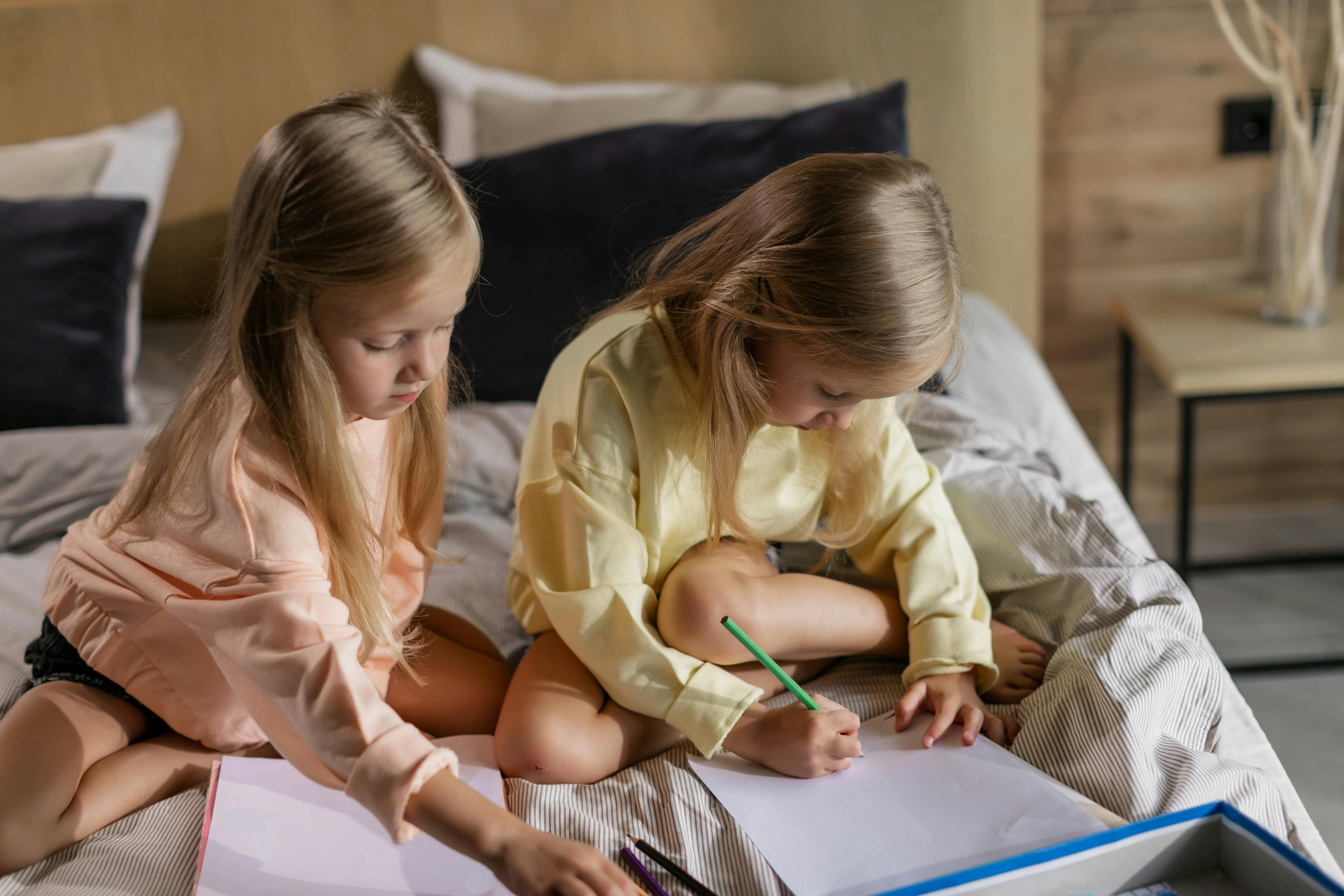 Girls Drawing on Papers in the Bed