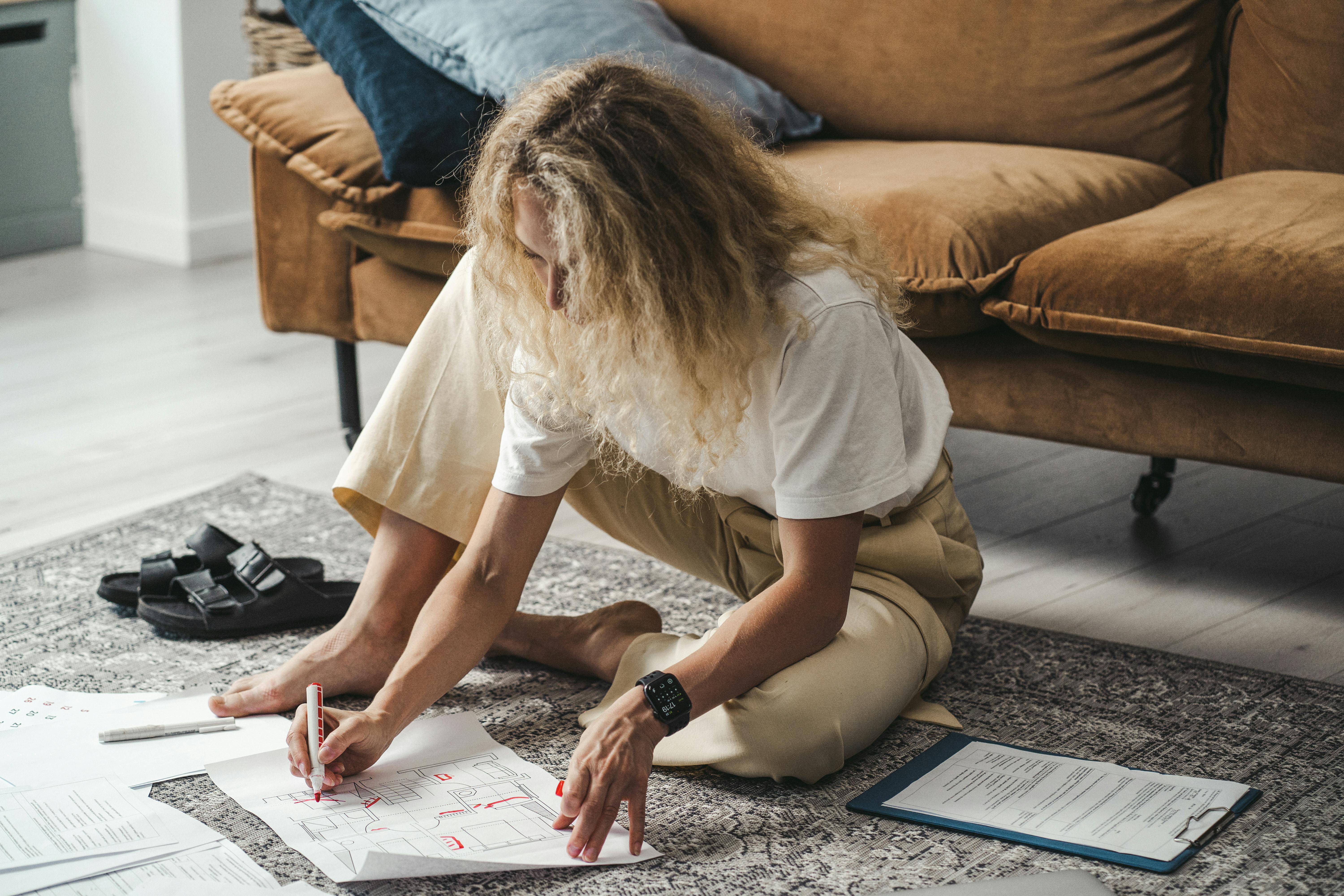 A Woman in White T-shirt Writing on a White Paper