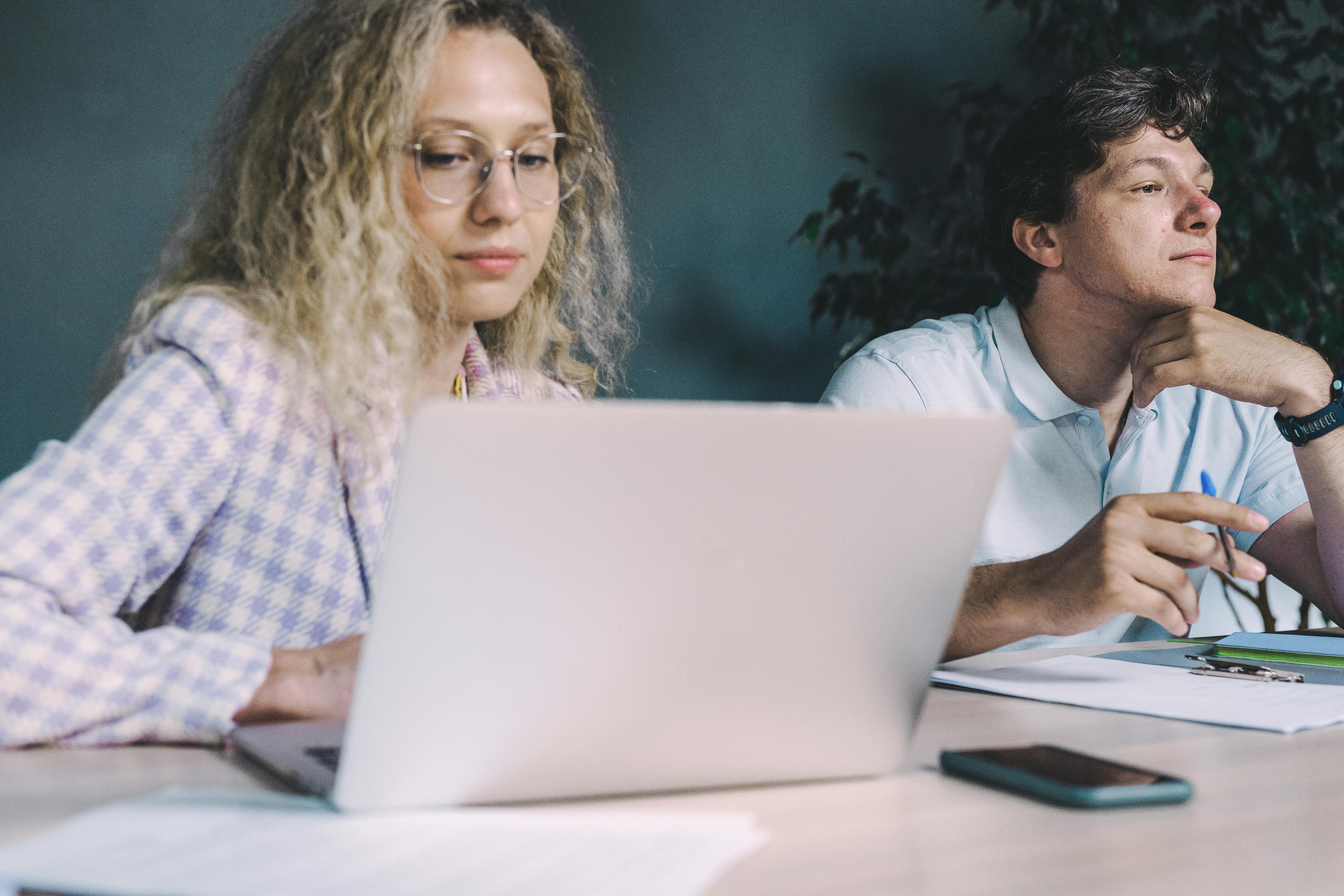 Woman Using Laptop Beside a Man