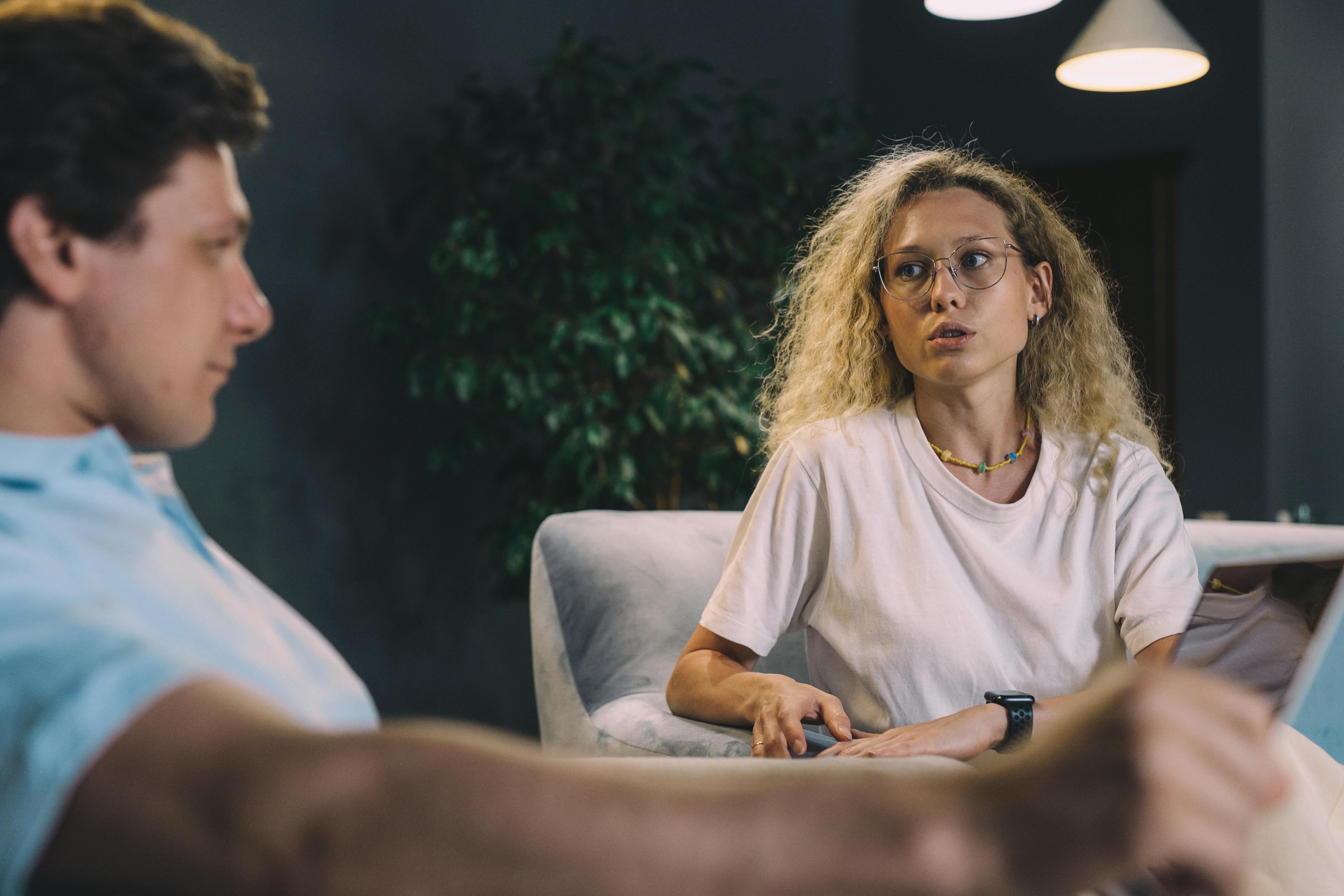A Woman in White Shirt Talking to the Man Sitting Near Her