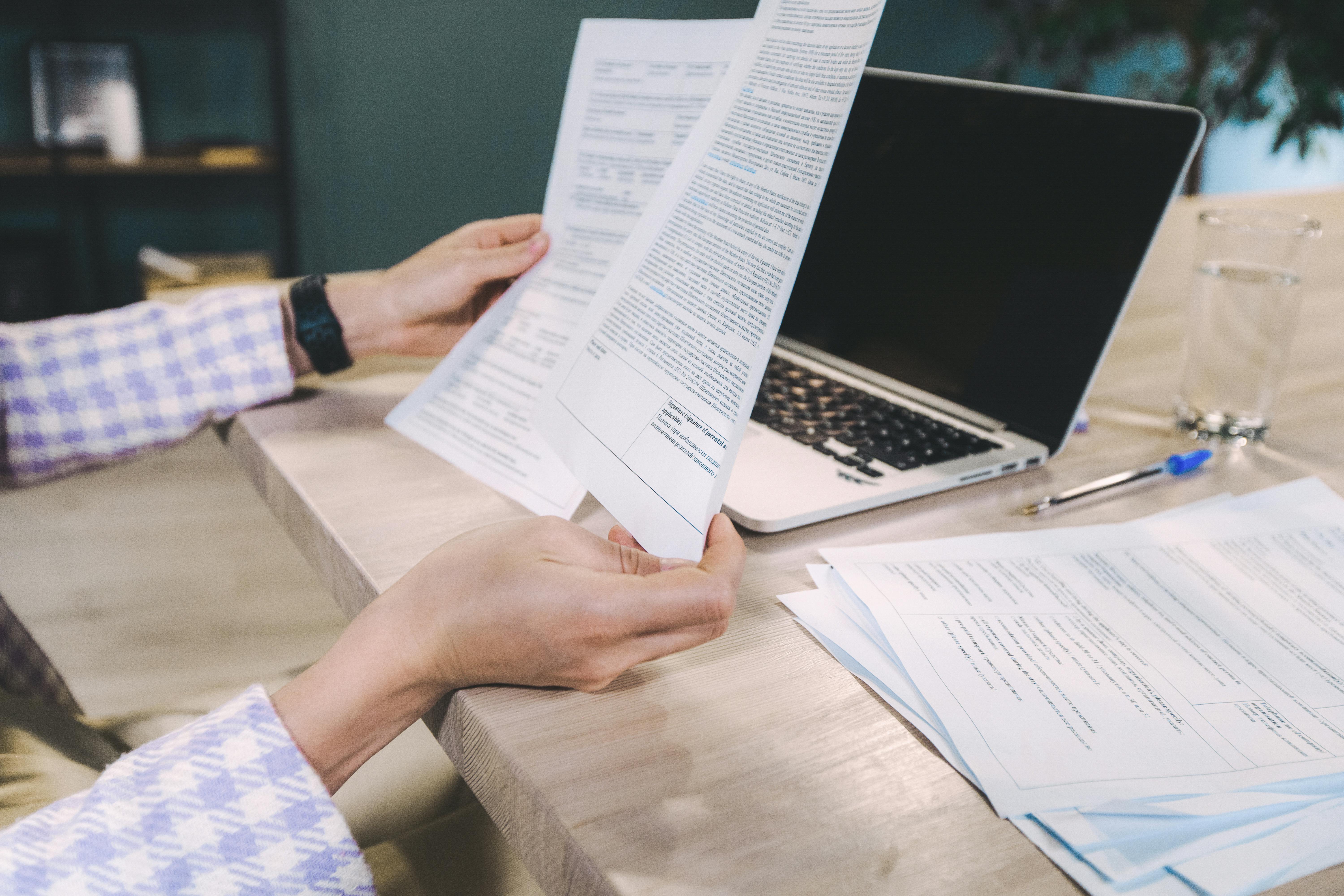 Person Holding White Printed Papers