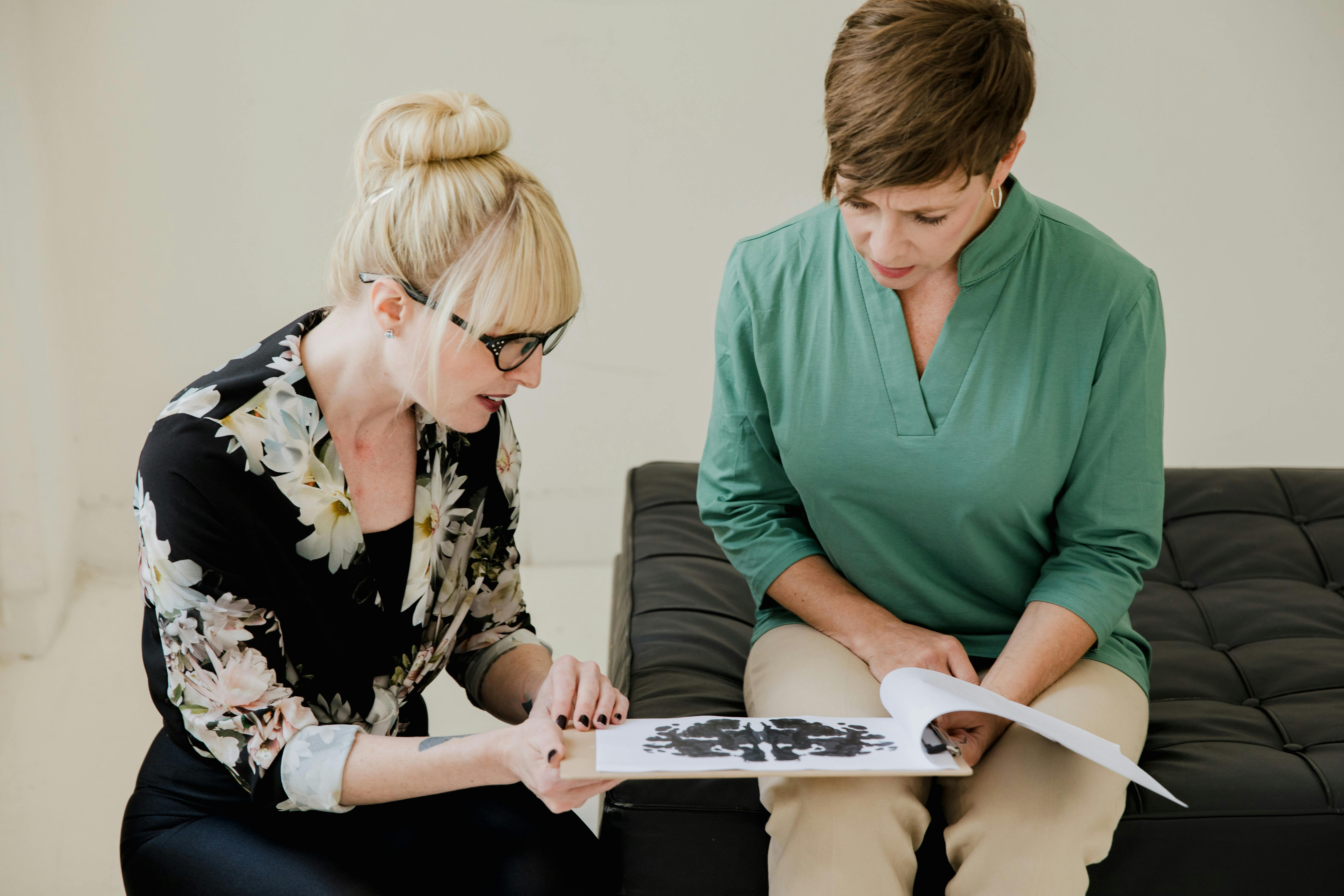 Women Discussing and Having Conversation While Sitting on a Couch