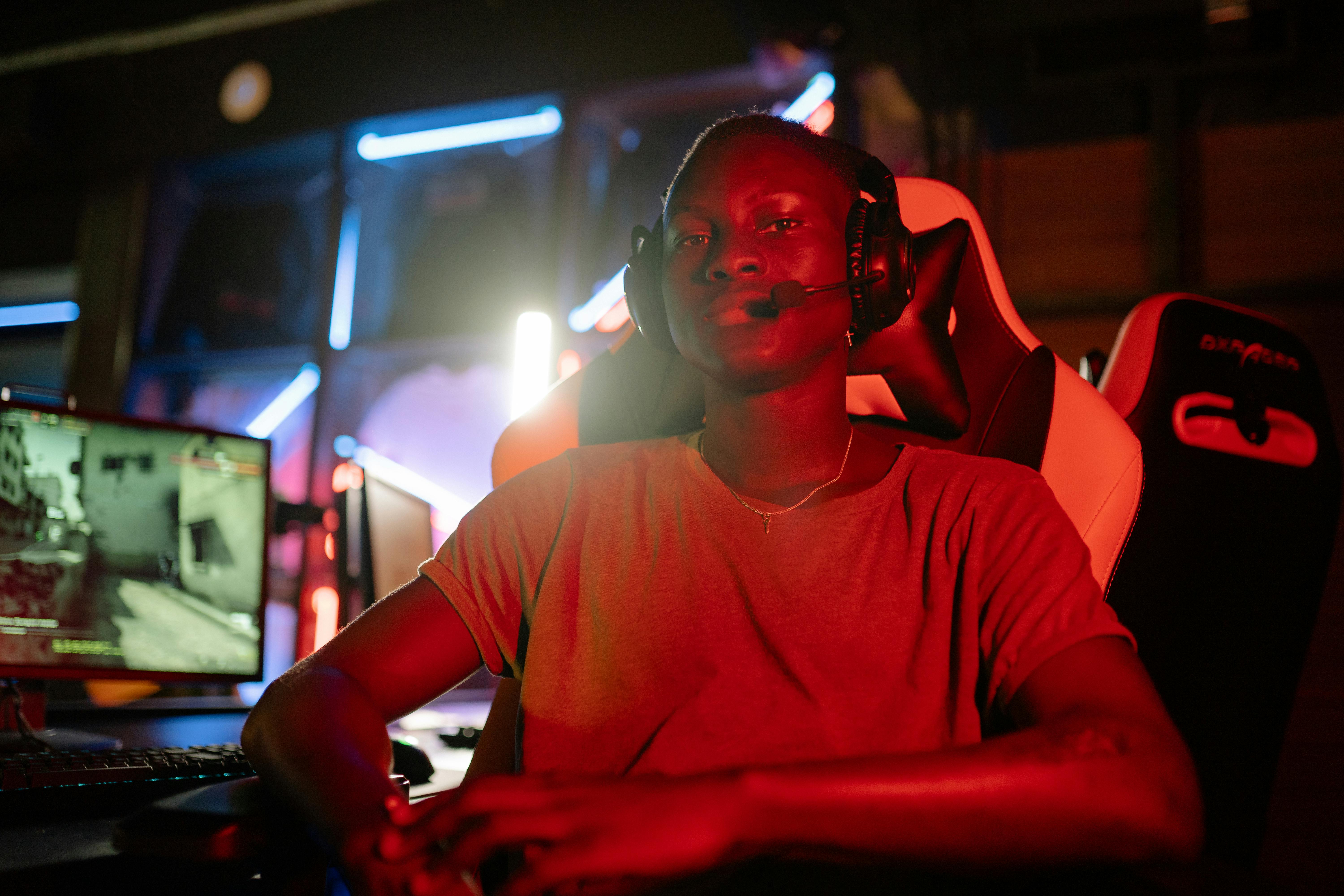 A Man Sitting at a Table with Computer Wearing Headphones