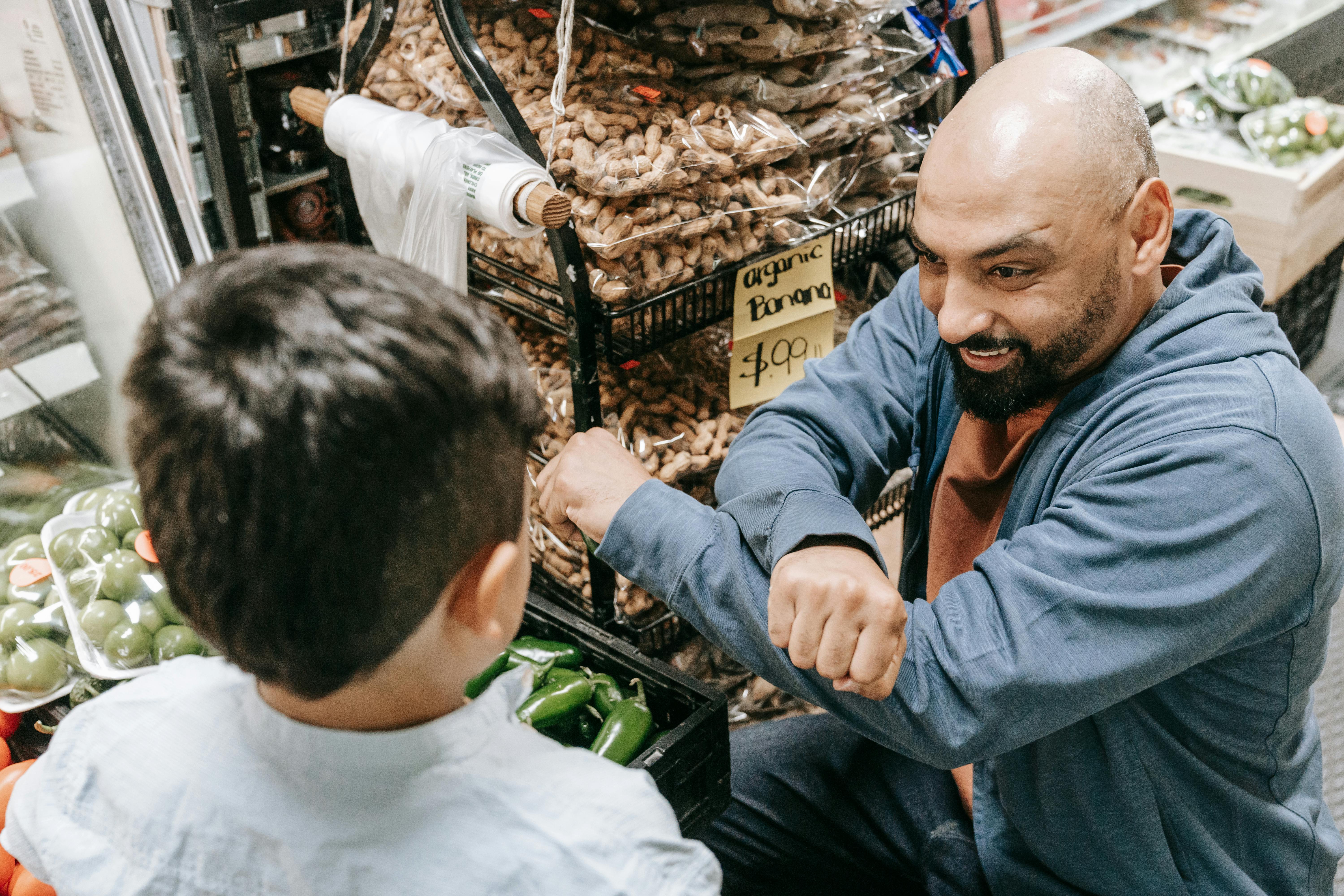Photo of a Boy and a Man at the Market