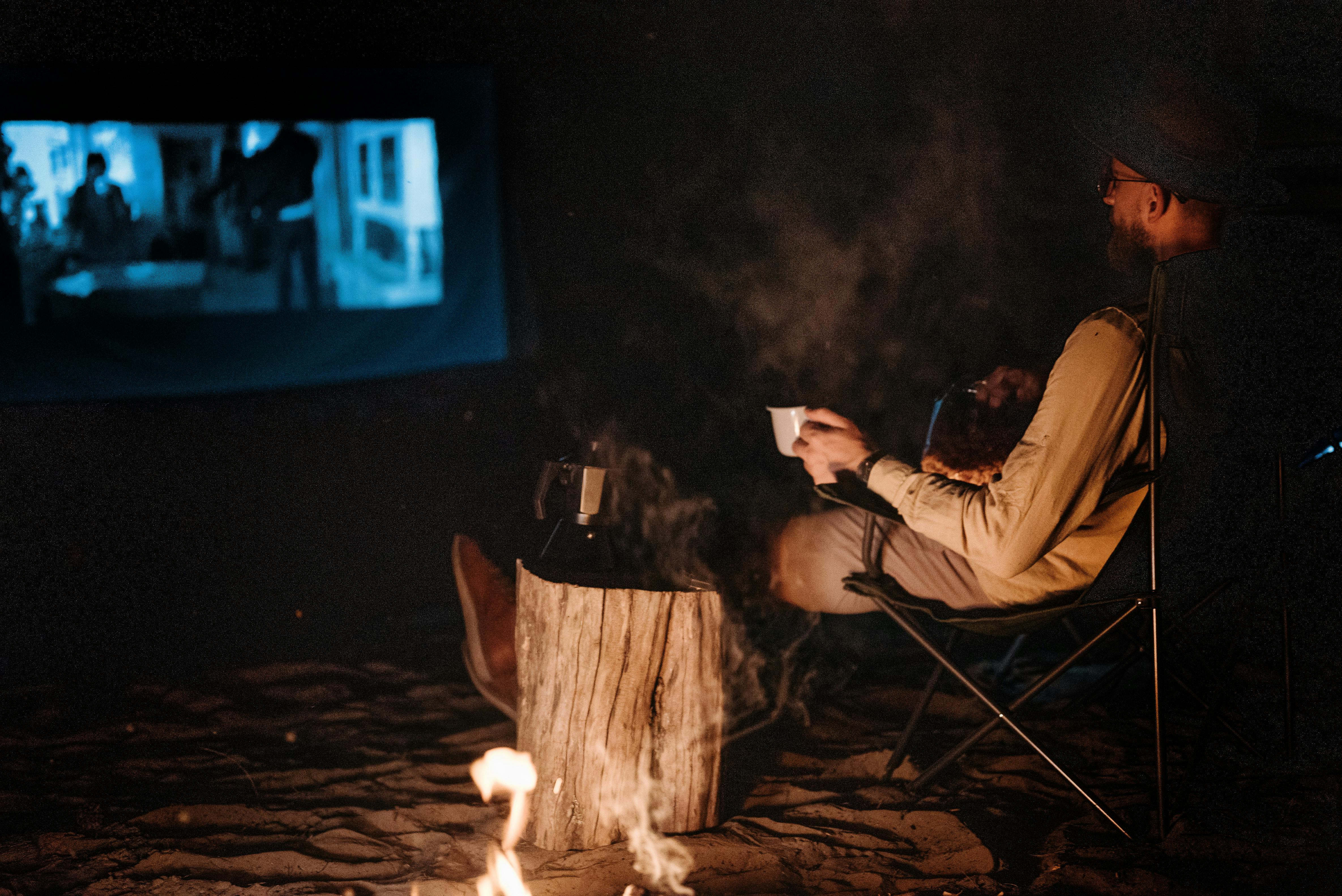 Man Watching Movie in Wilderness at Night