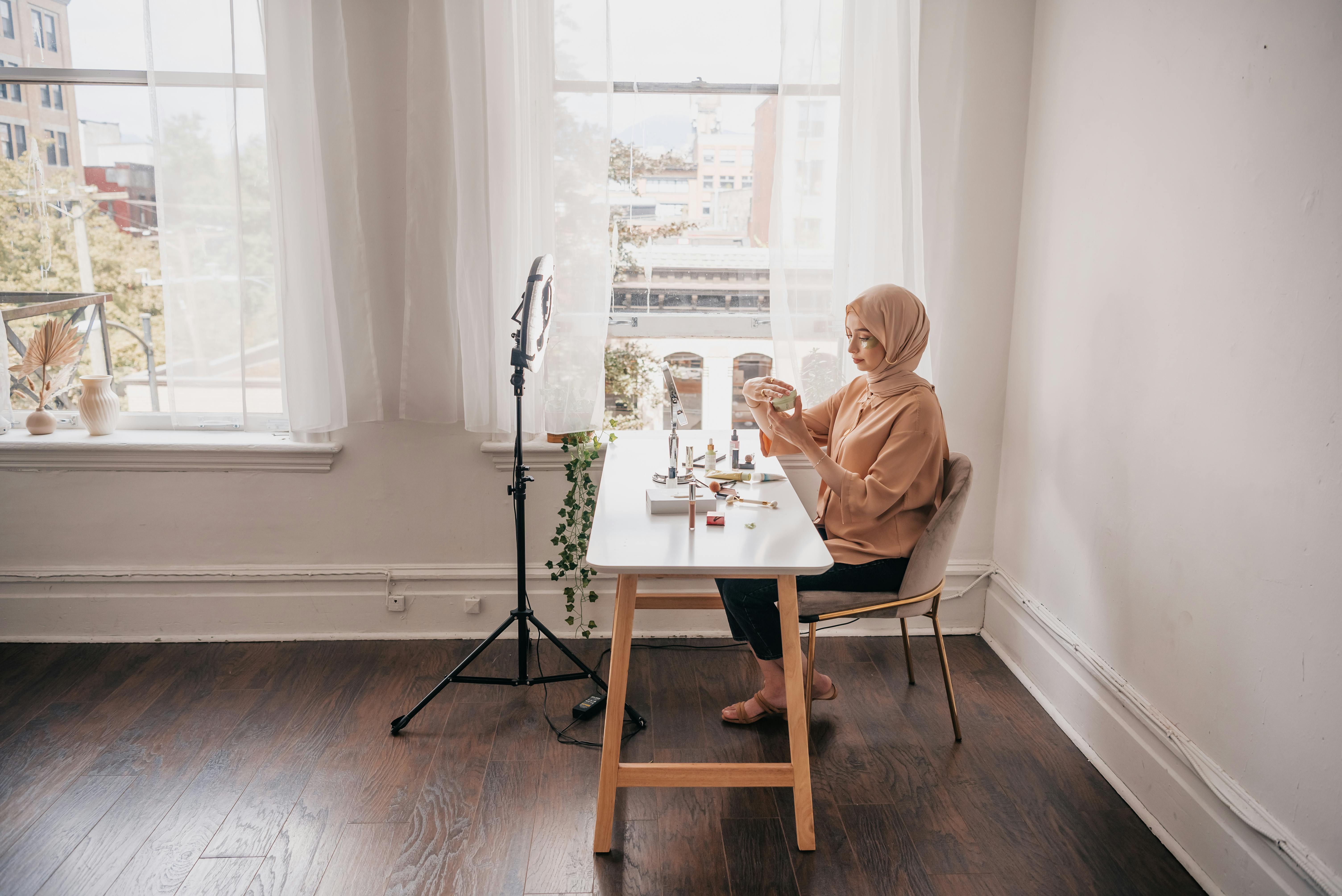 Woman Sitting at Table with Cosmetics