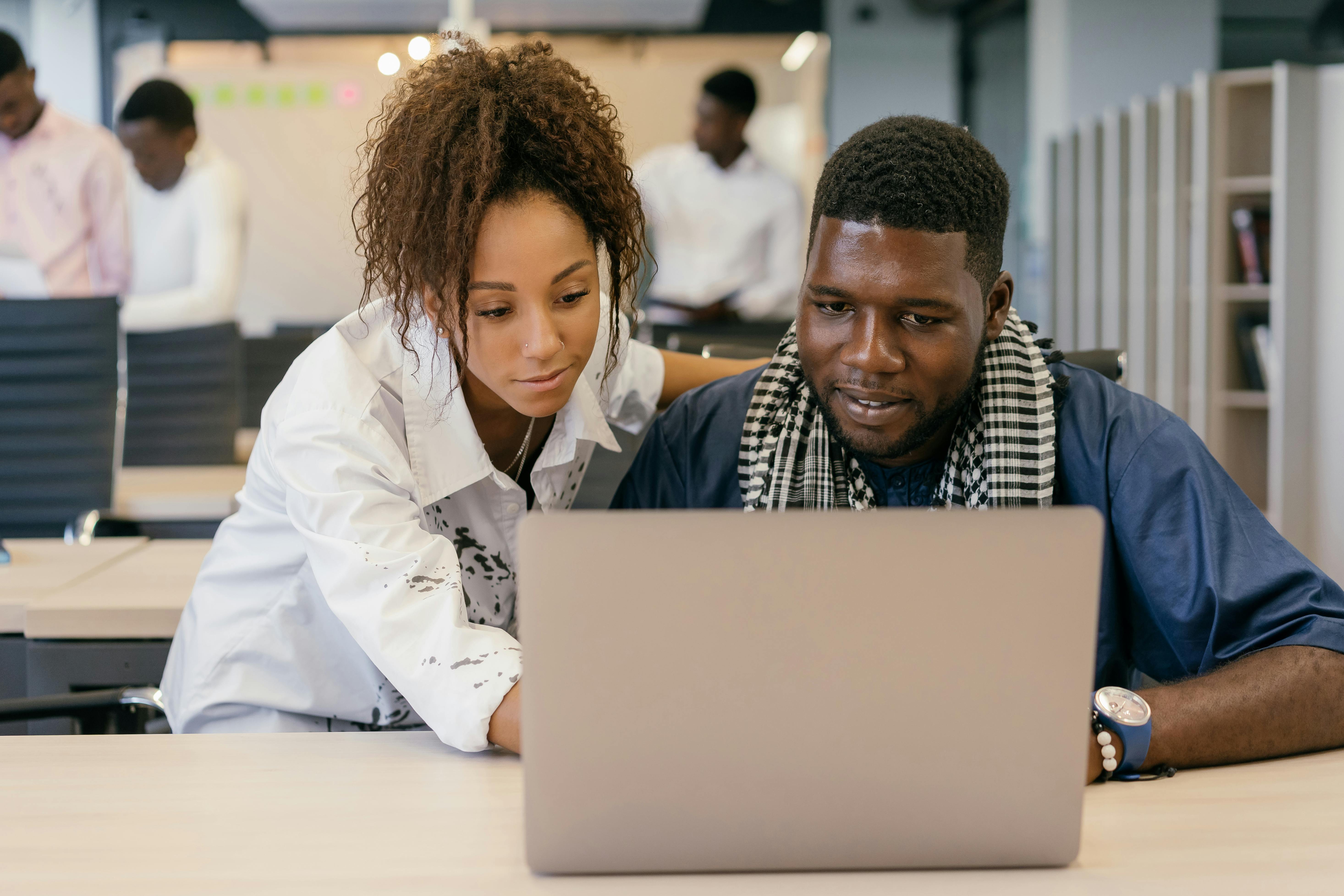 Man and Woman Looking at a Laptop