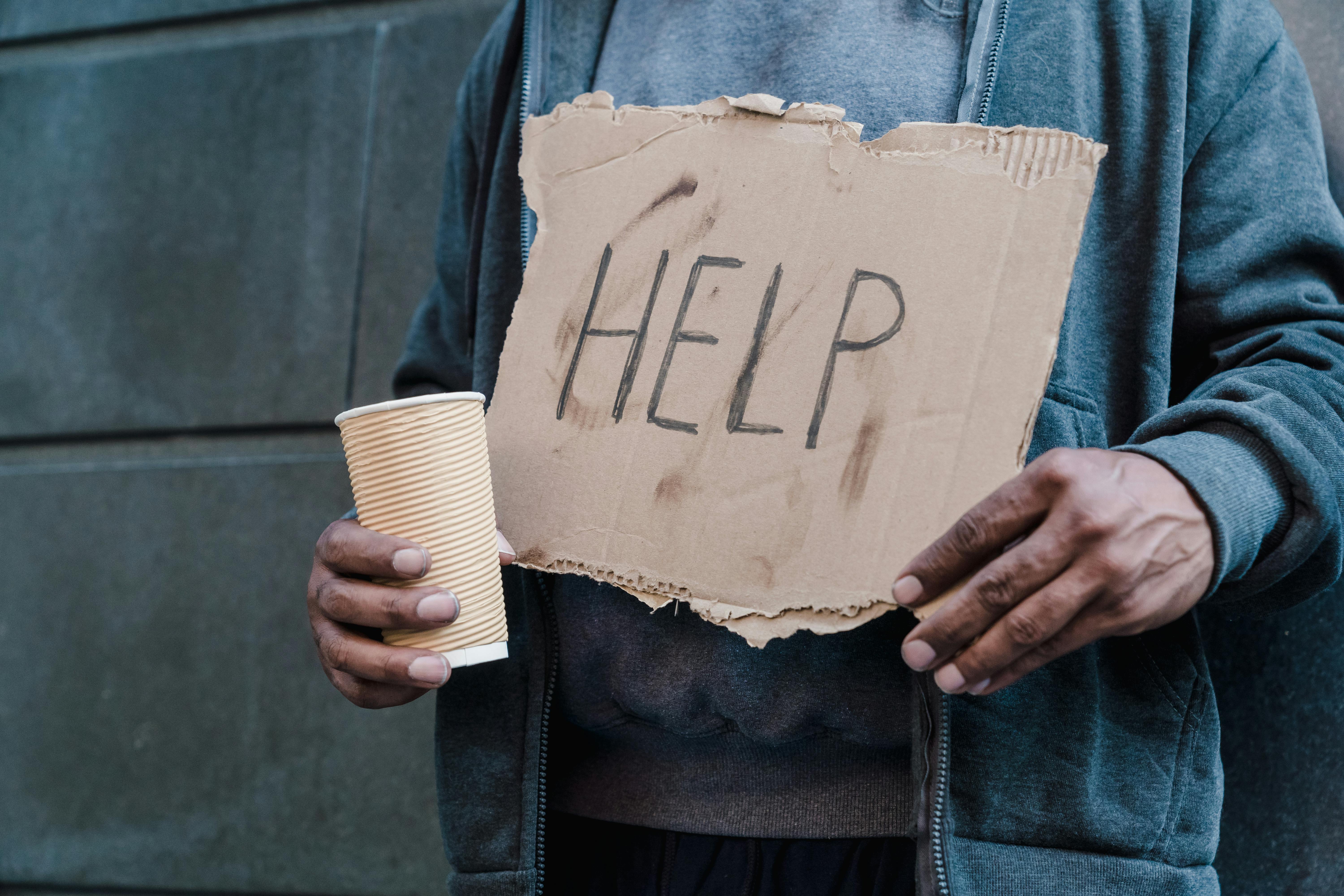 Man Holding Cup and Cardboard