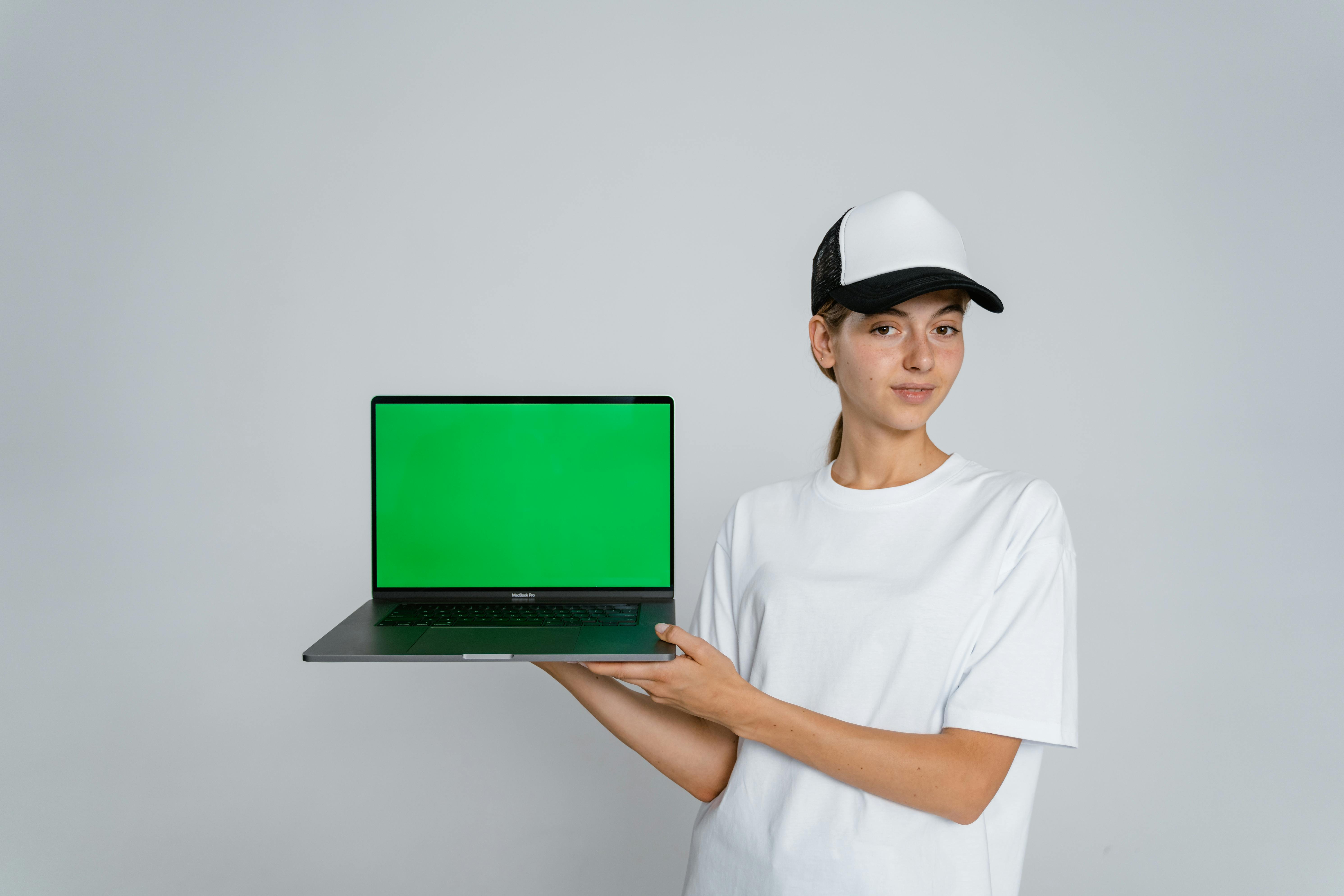 Woman in White Crew Neck T-shirt Holding Green Laptop Computer