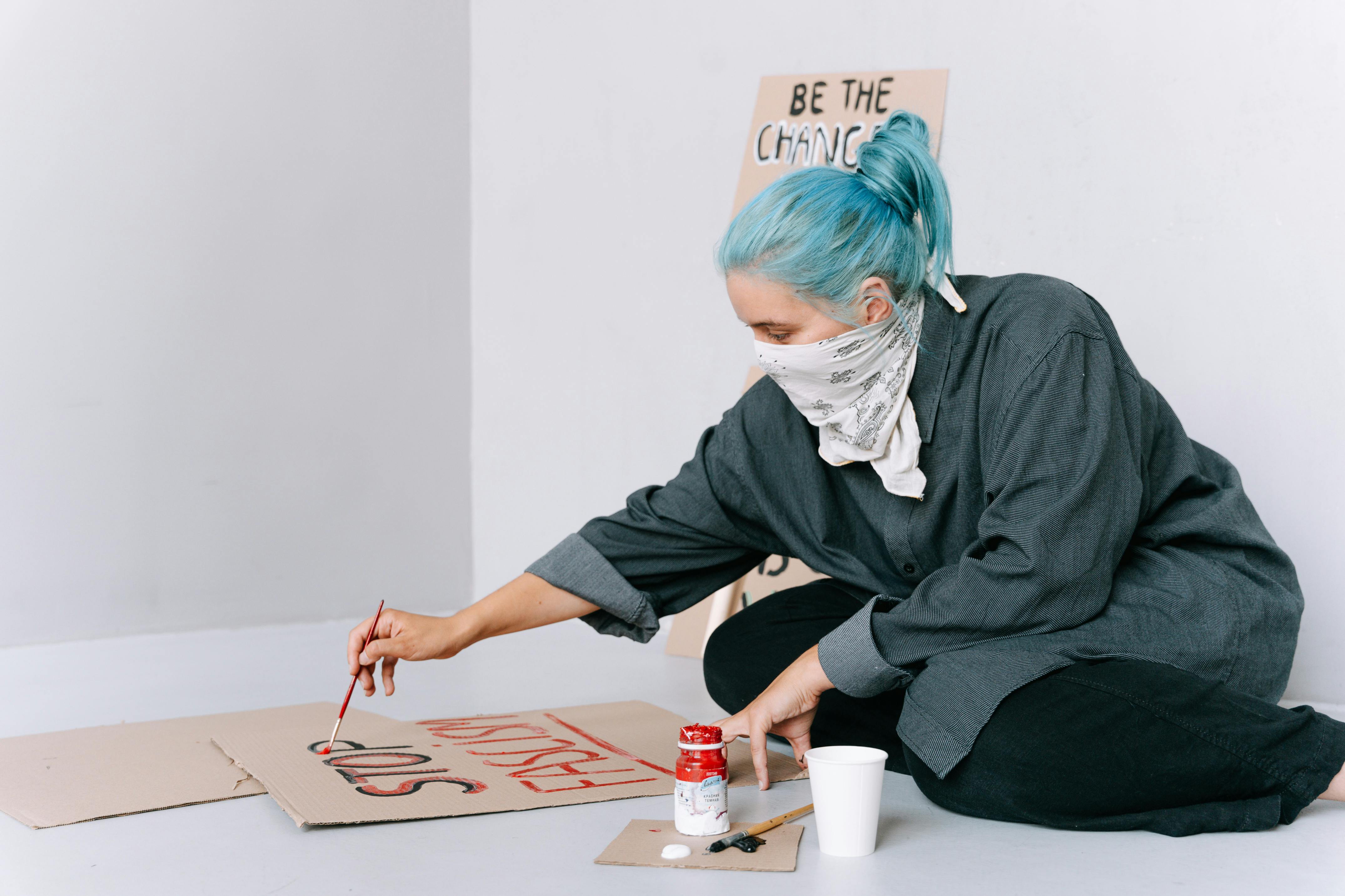 A Woman with Blue Hair Making a Poster