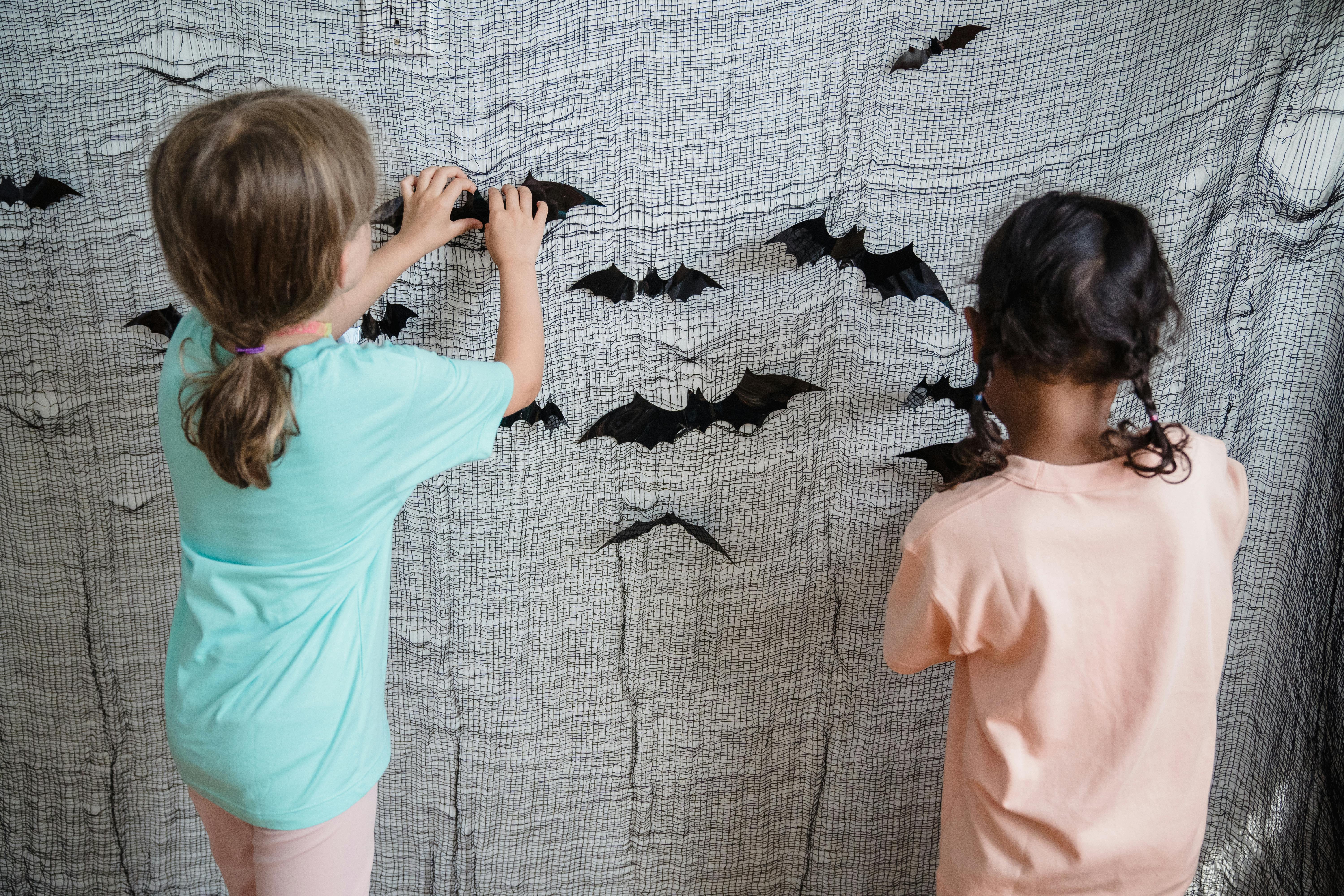 Rear view on kid pinning bats for Halloween