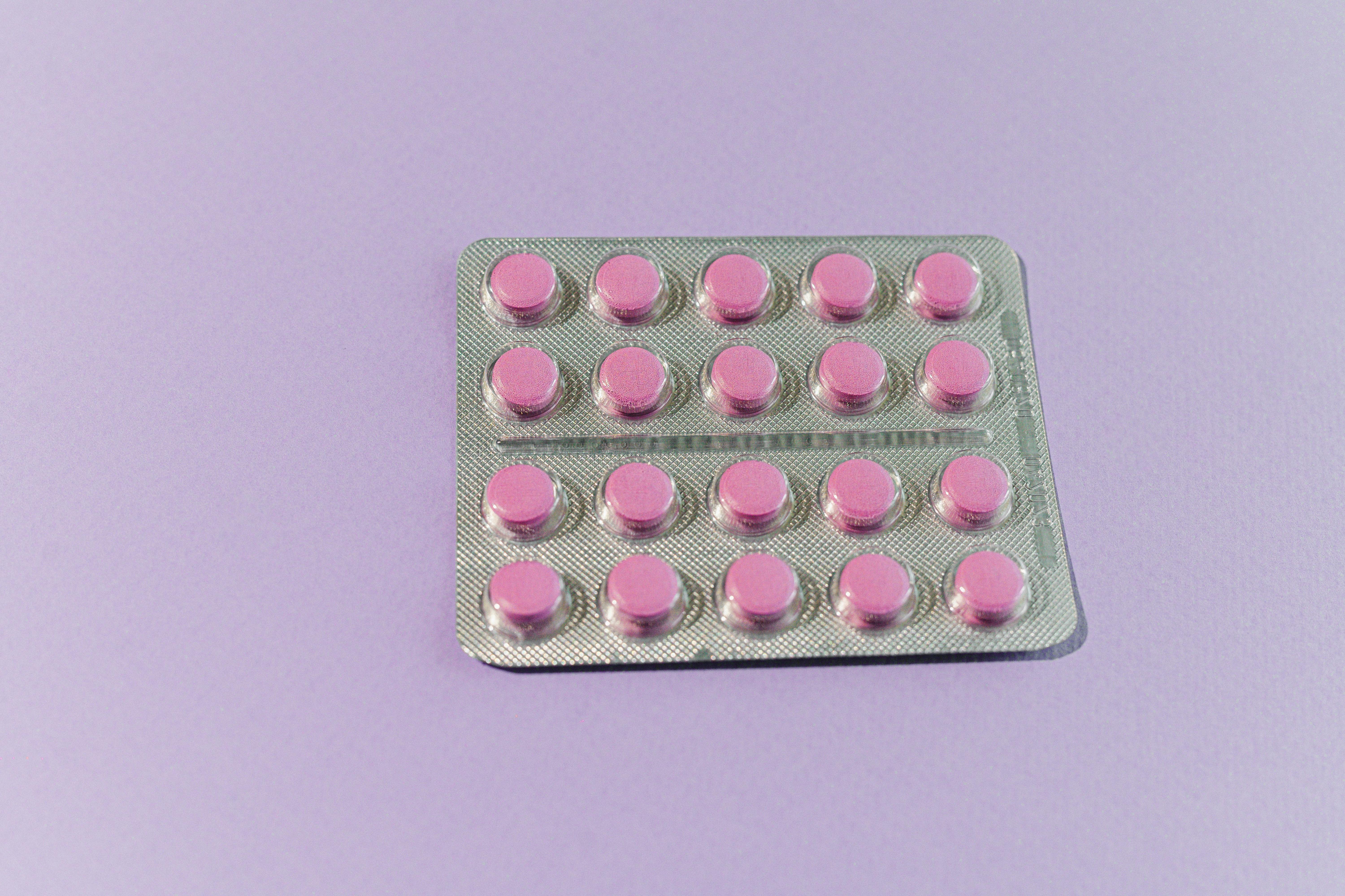 Pink Medicine Tablets on White Surface
