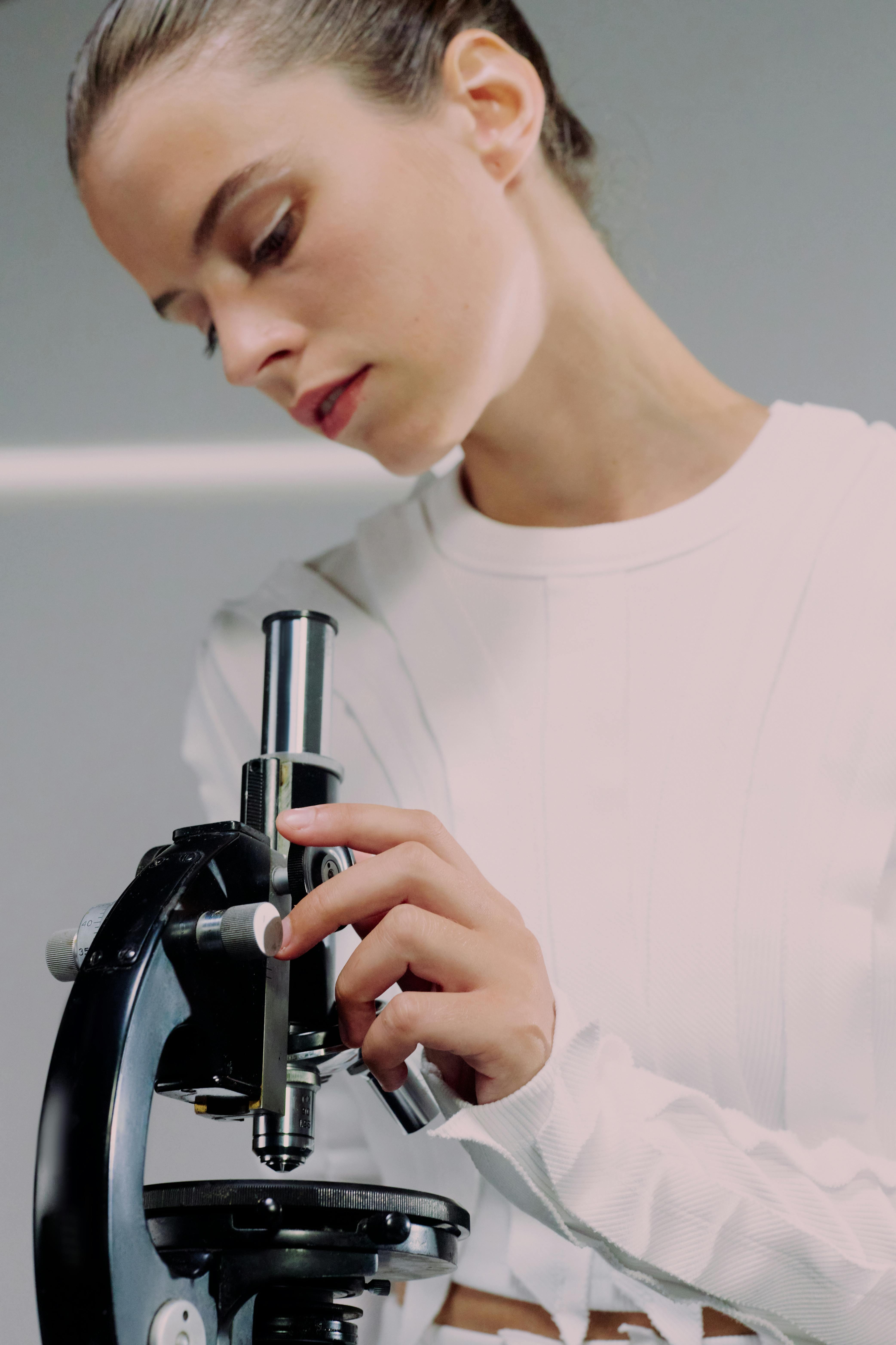 A female scientist looking through microscope