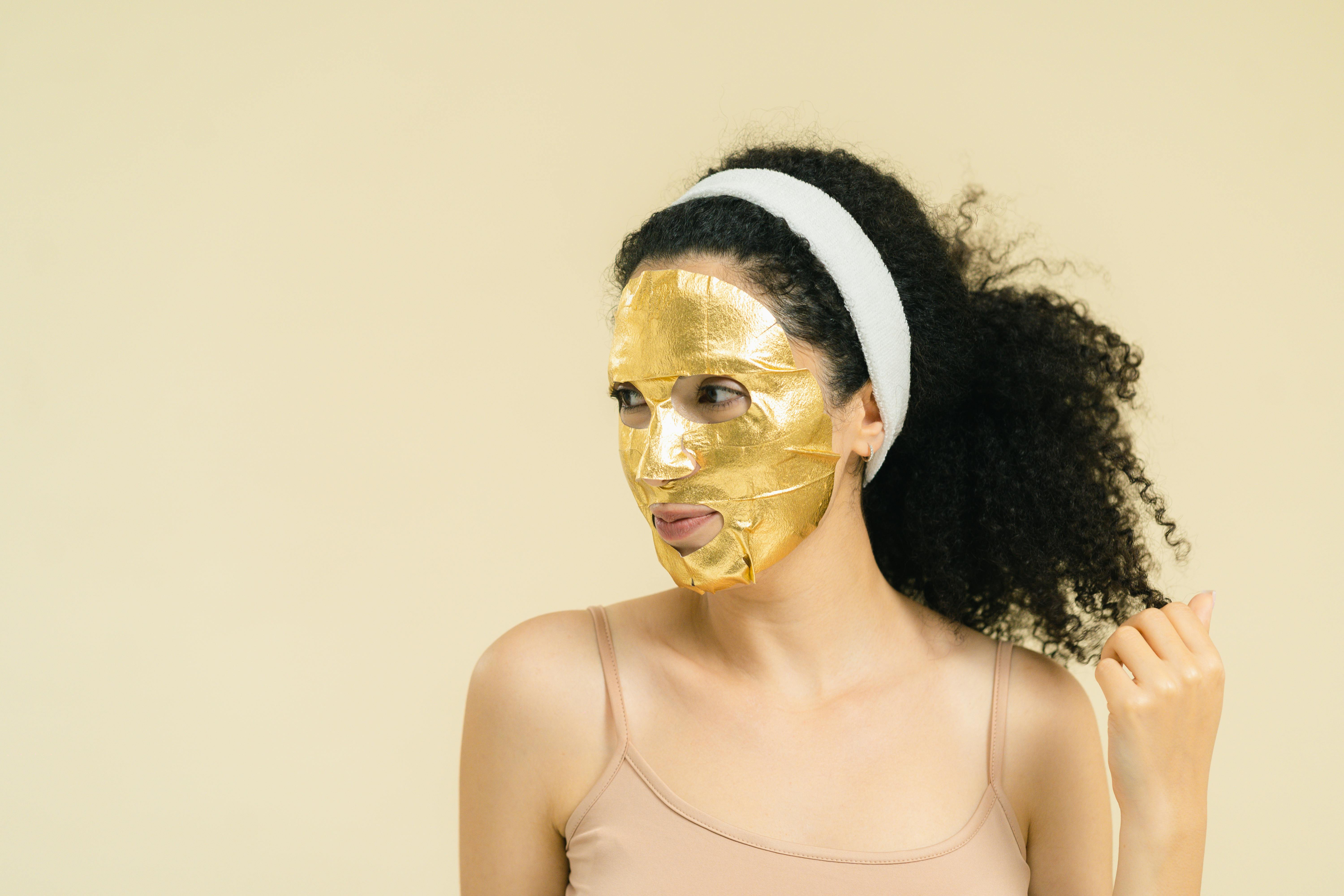 A Woman Wearing a Gold Facial Mask