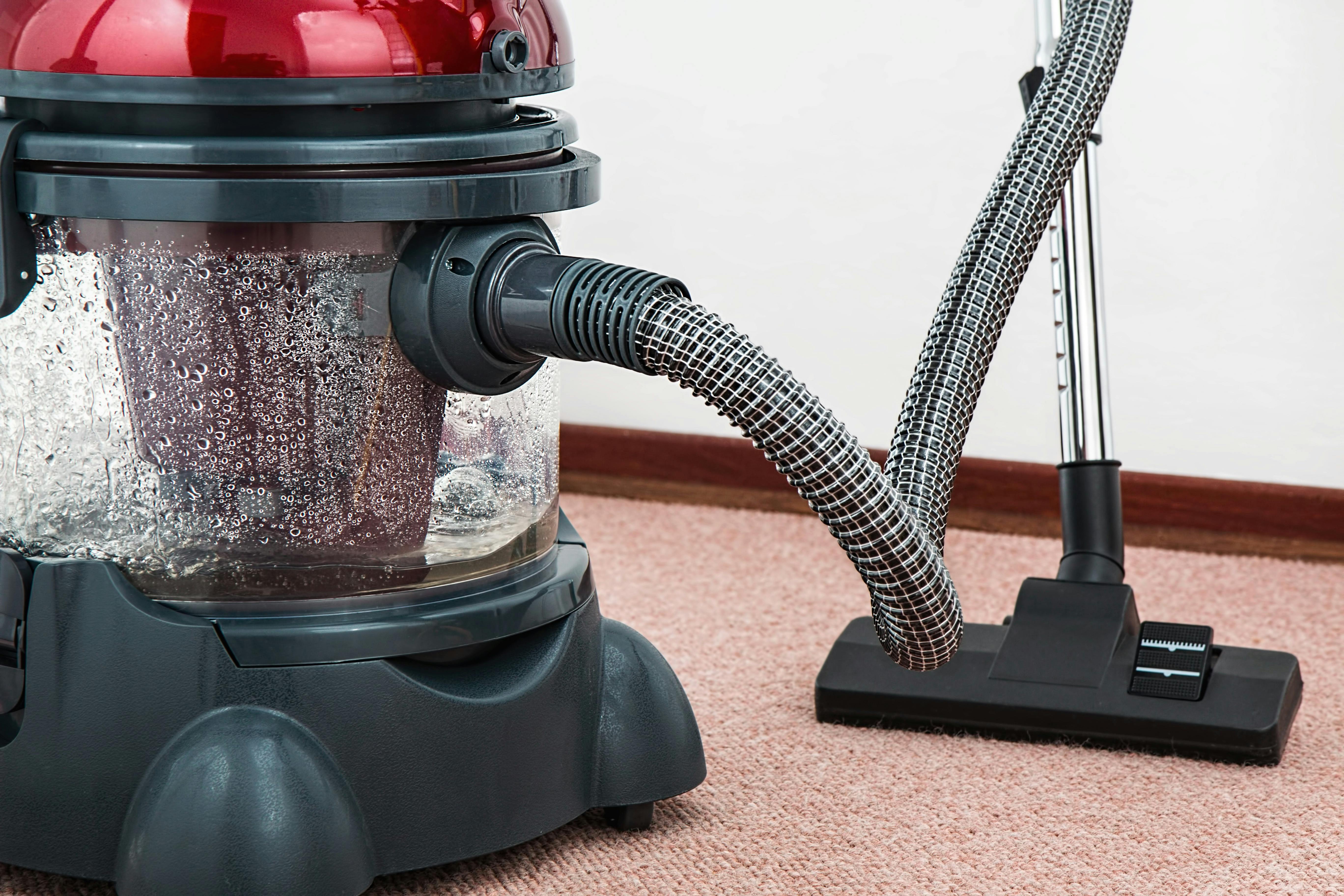 Black and Red Canister Vacuum Cleaner on Floor