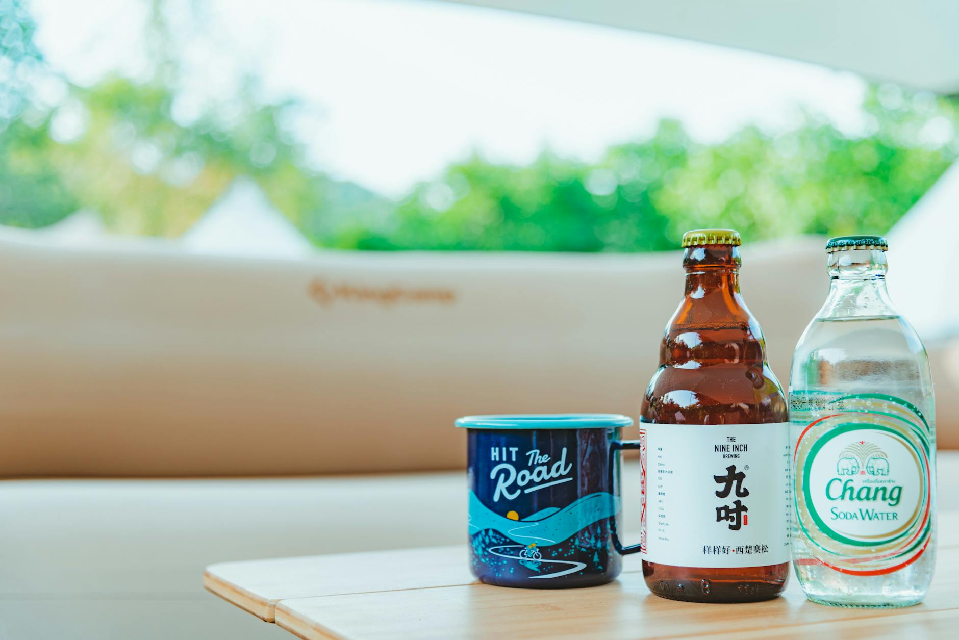 A Mug Beside Labelled Bottle on Wooden Surface