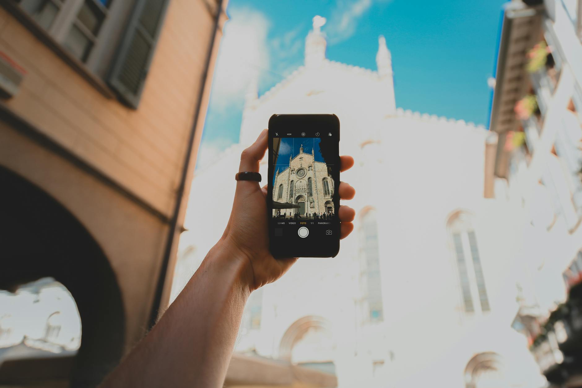 Person Holding Black Mobile Phone Taking Photo of White Concrete Building