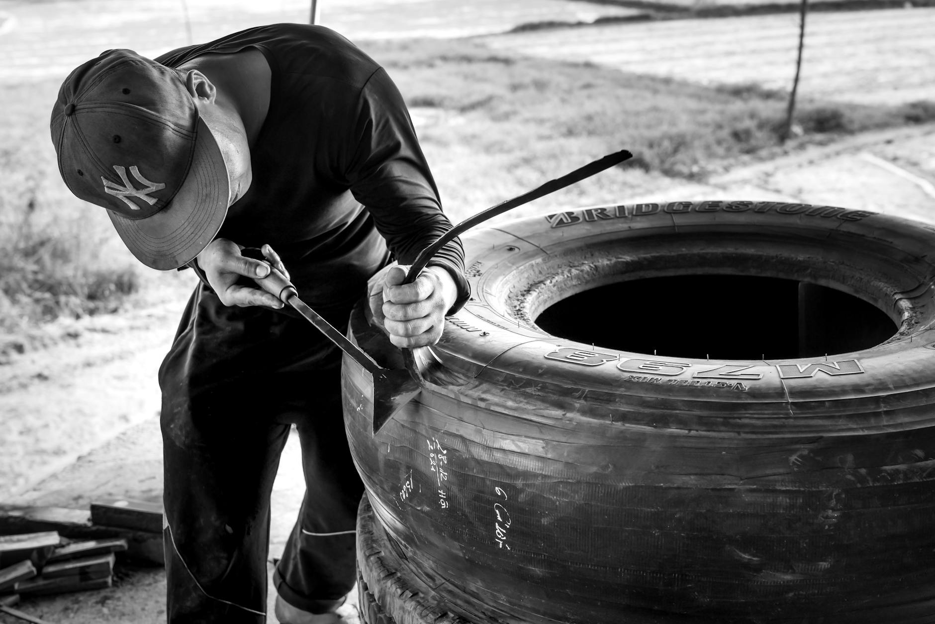 Man in Black Long Sleeve Shirt Fixing a Tire