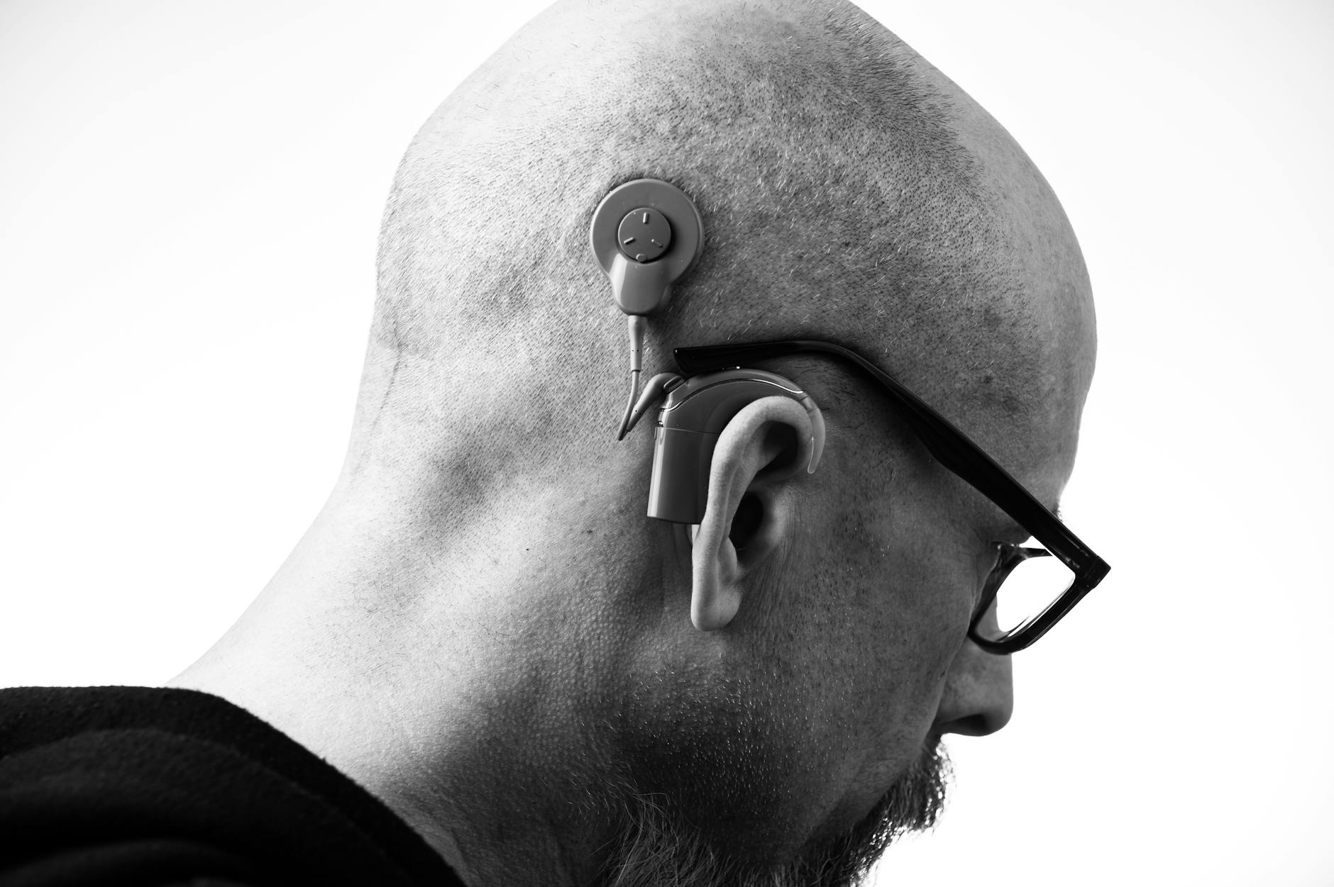 Grayscale Photo of a Man with a Hearing Aid