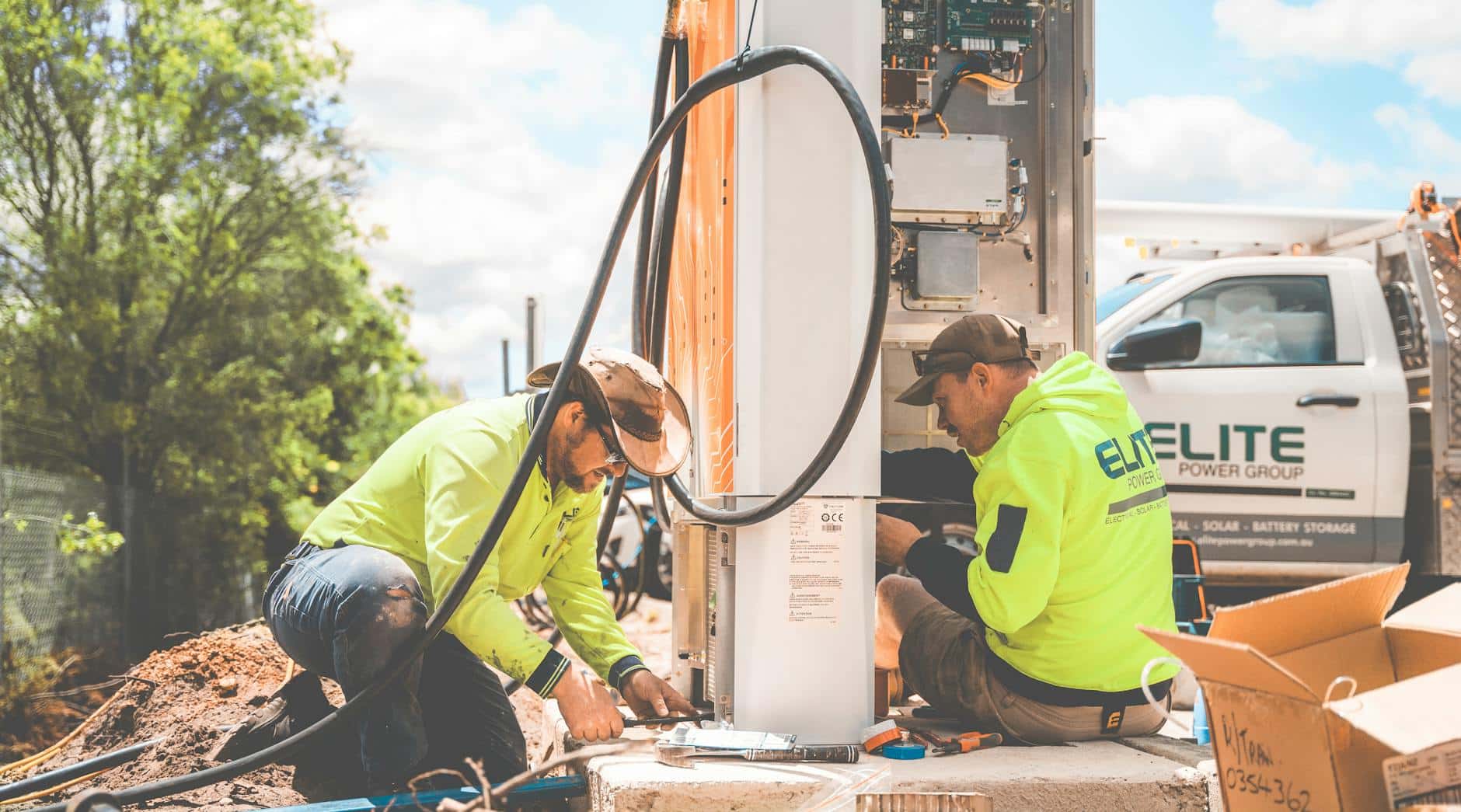 Electricians Sitting and Working on Box