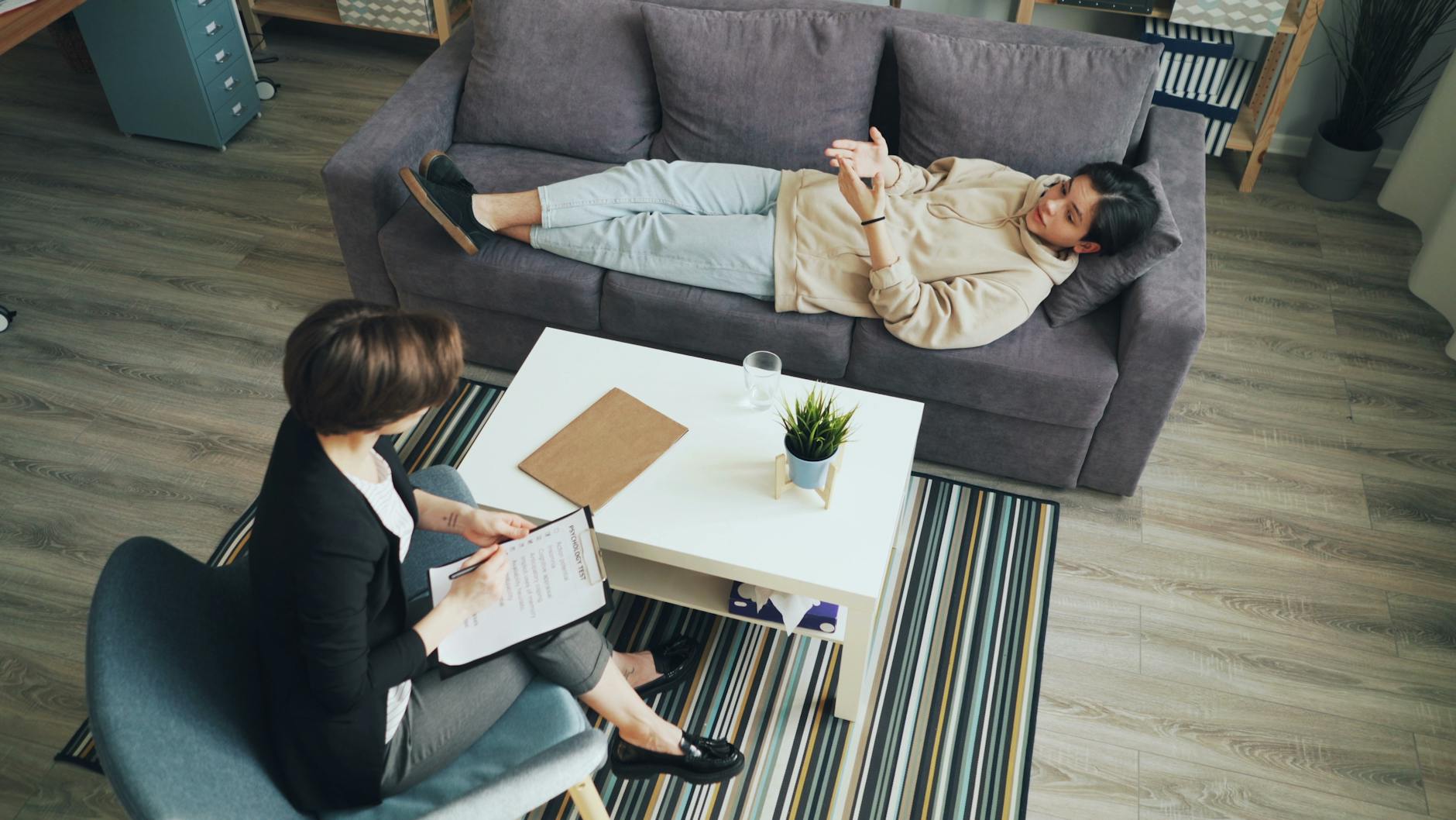 A woman sitting comfortably on a couch with a man on the floor