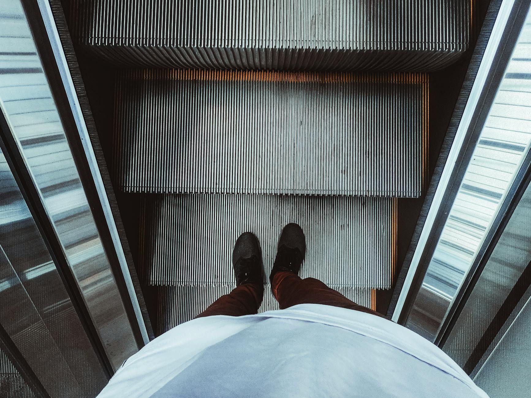 High Angle Photo of Person on Escalator