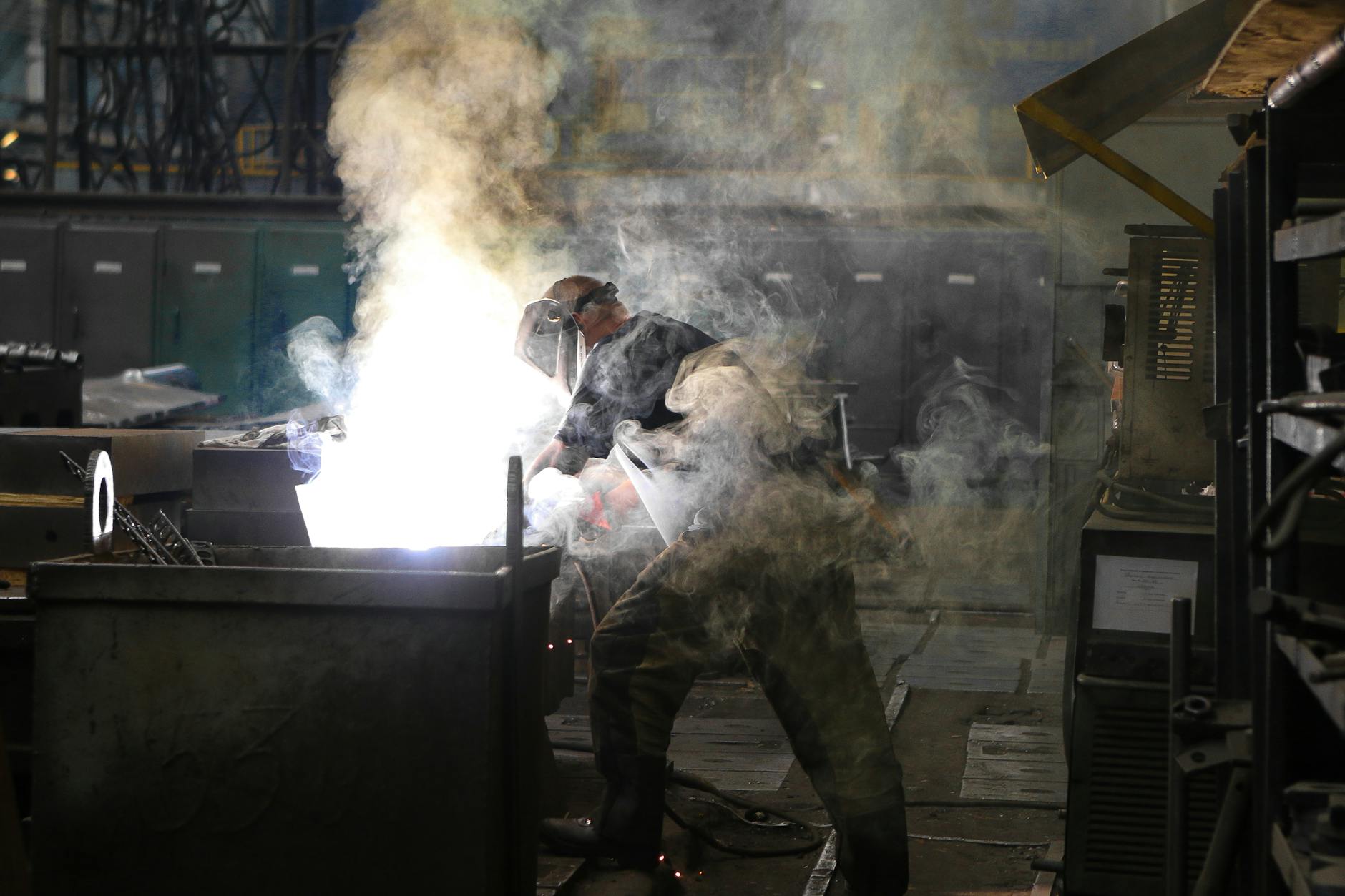 A worker in a safety mask welding titanium components