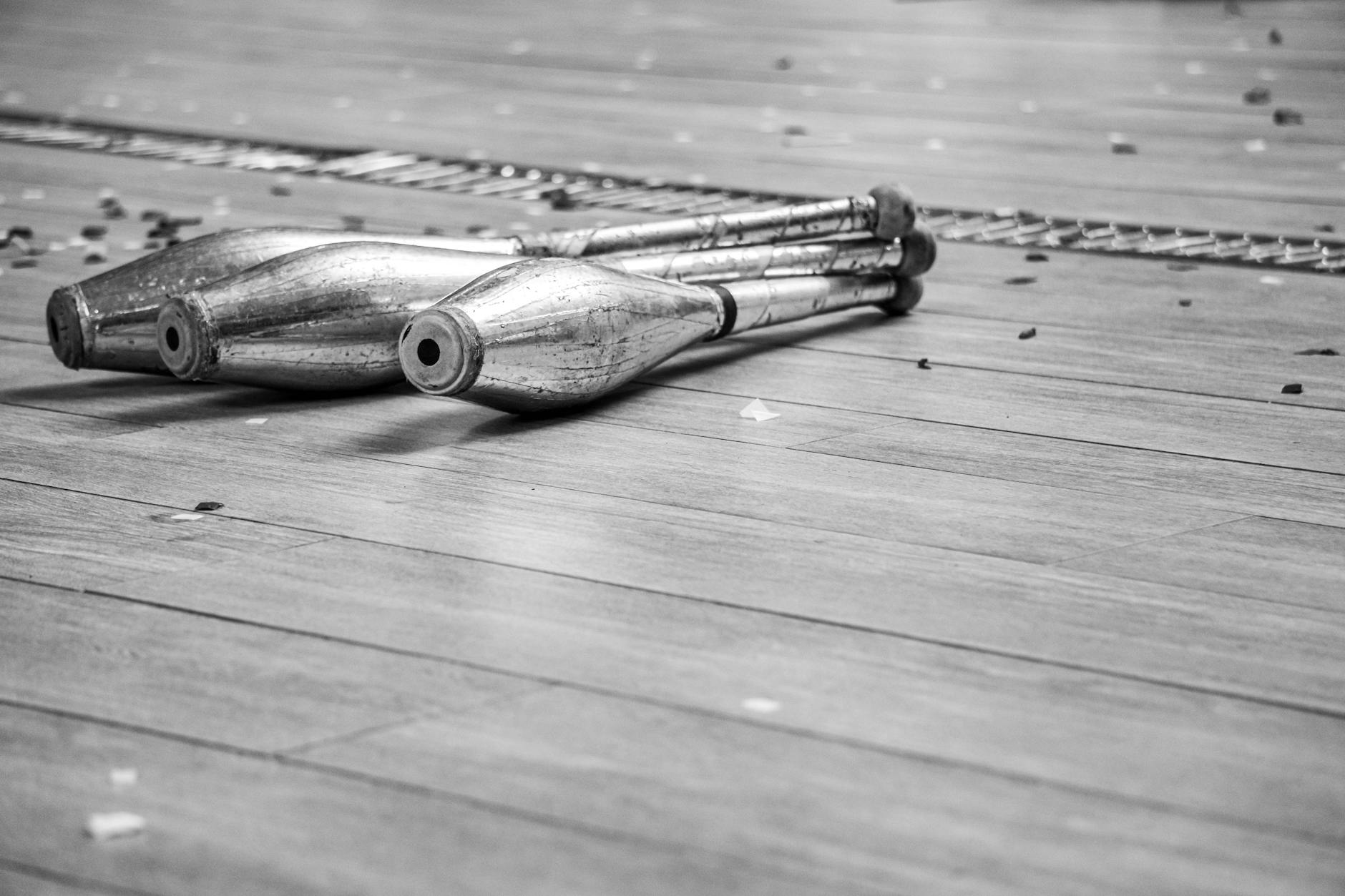 Black and White Juggling Clubs on Wooden Floor