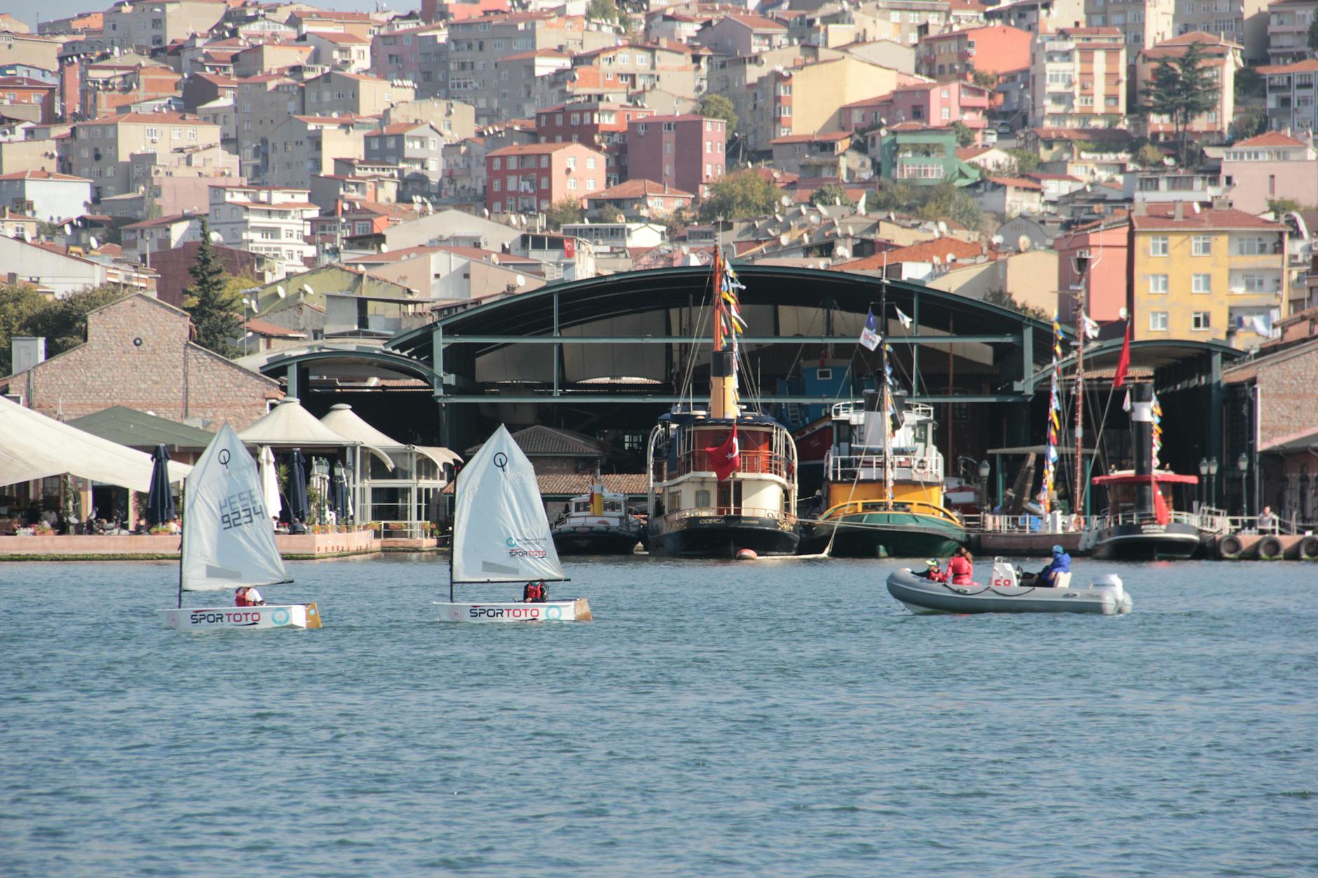 Sailboats and vibrant waterfront buildings in a bustling harbor setting.