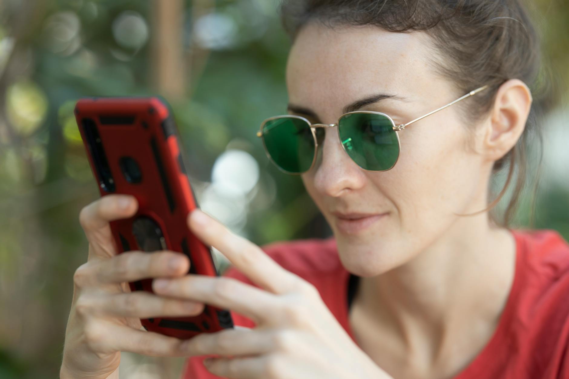 Woman Holding Smartphone and Wearing Sunglasses