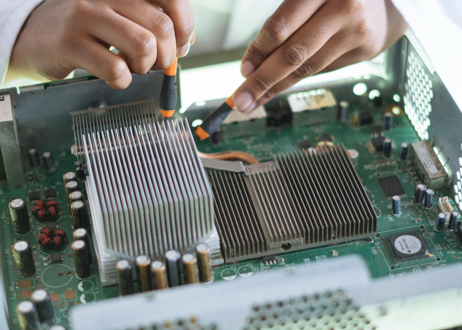 Crop technician checking contacts on motherboard in workshop