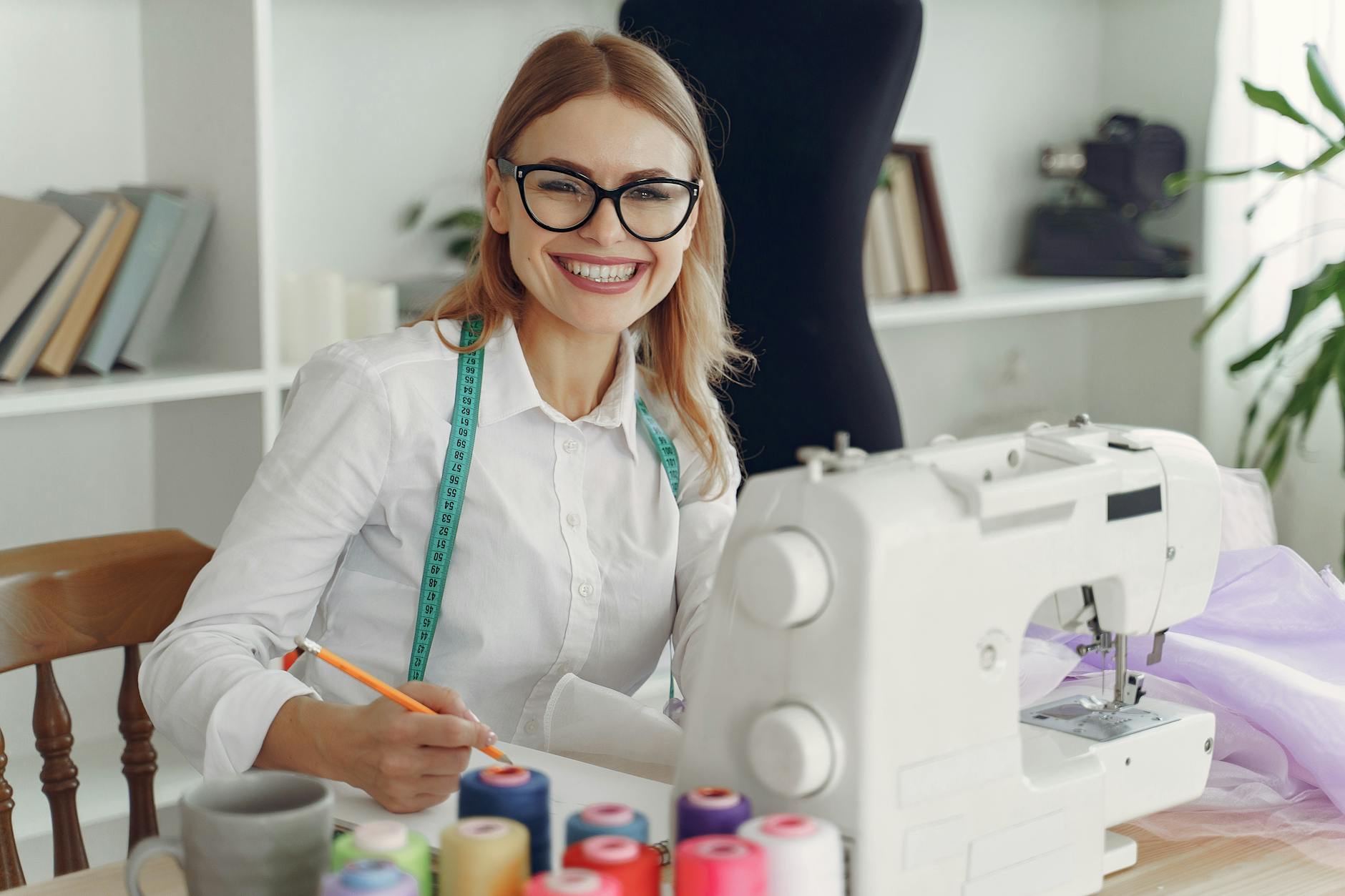 Dressmaker in front of her Sewing Machine Smiling