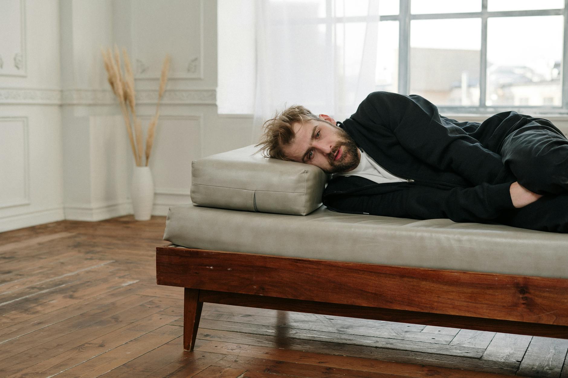 Woman in Black Long Sleeve Shirt Lying on Gray Couch