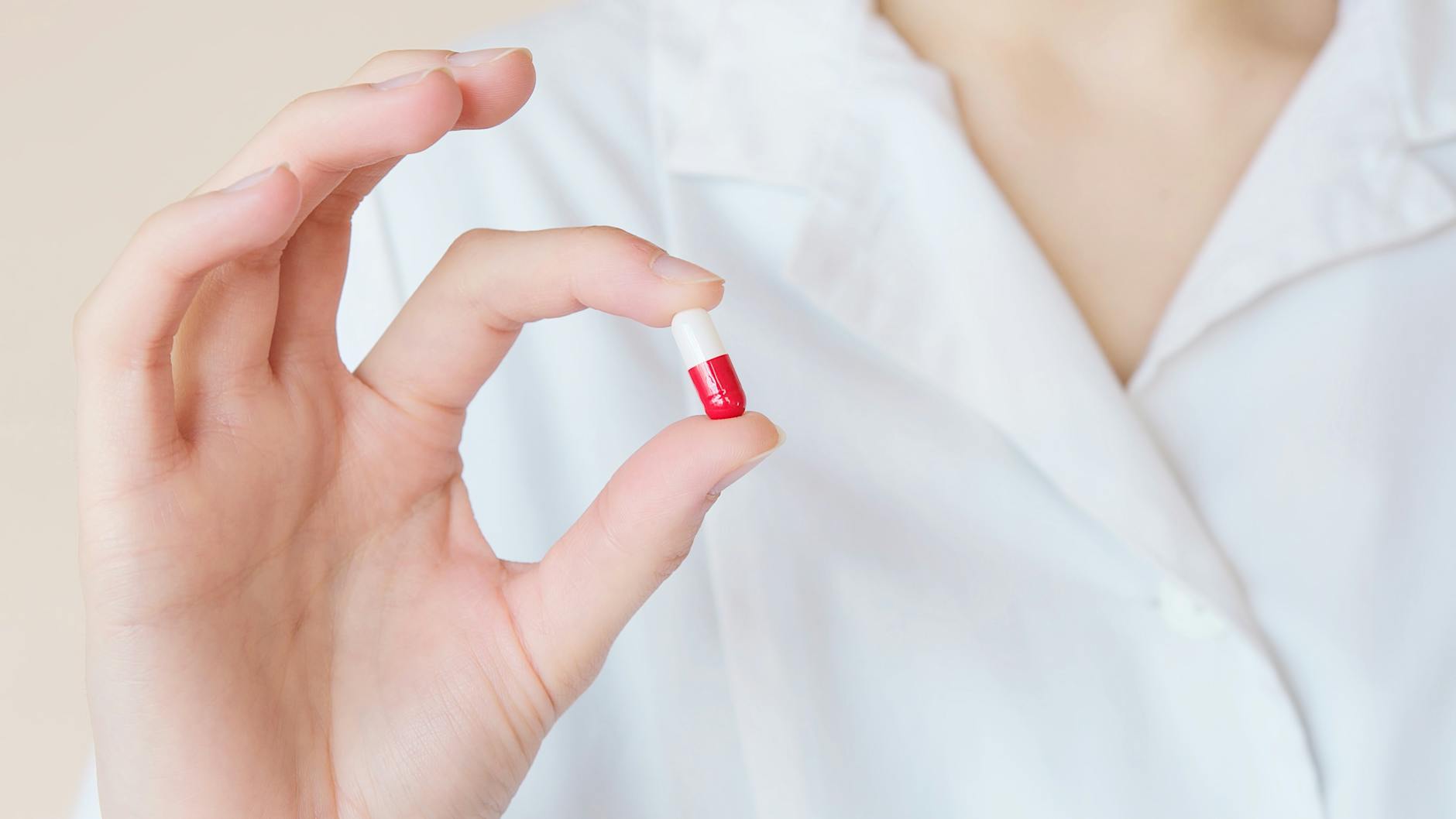 Crop nurse demonstrating small double colored pill