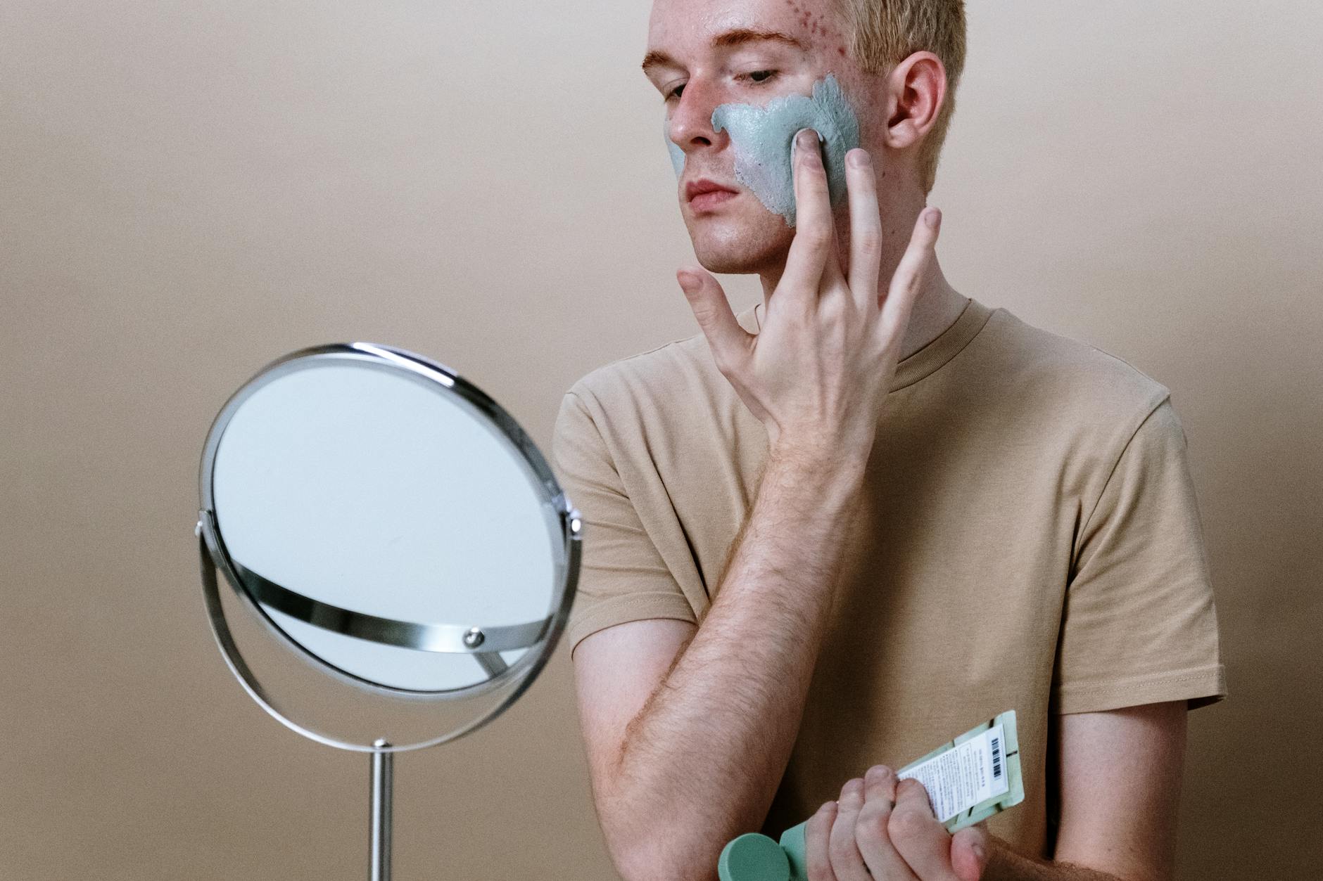 Man in Brown Crew Neck T-shirt Holding Round Mirror